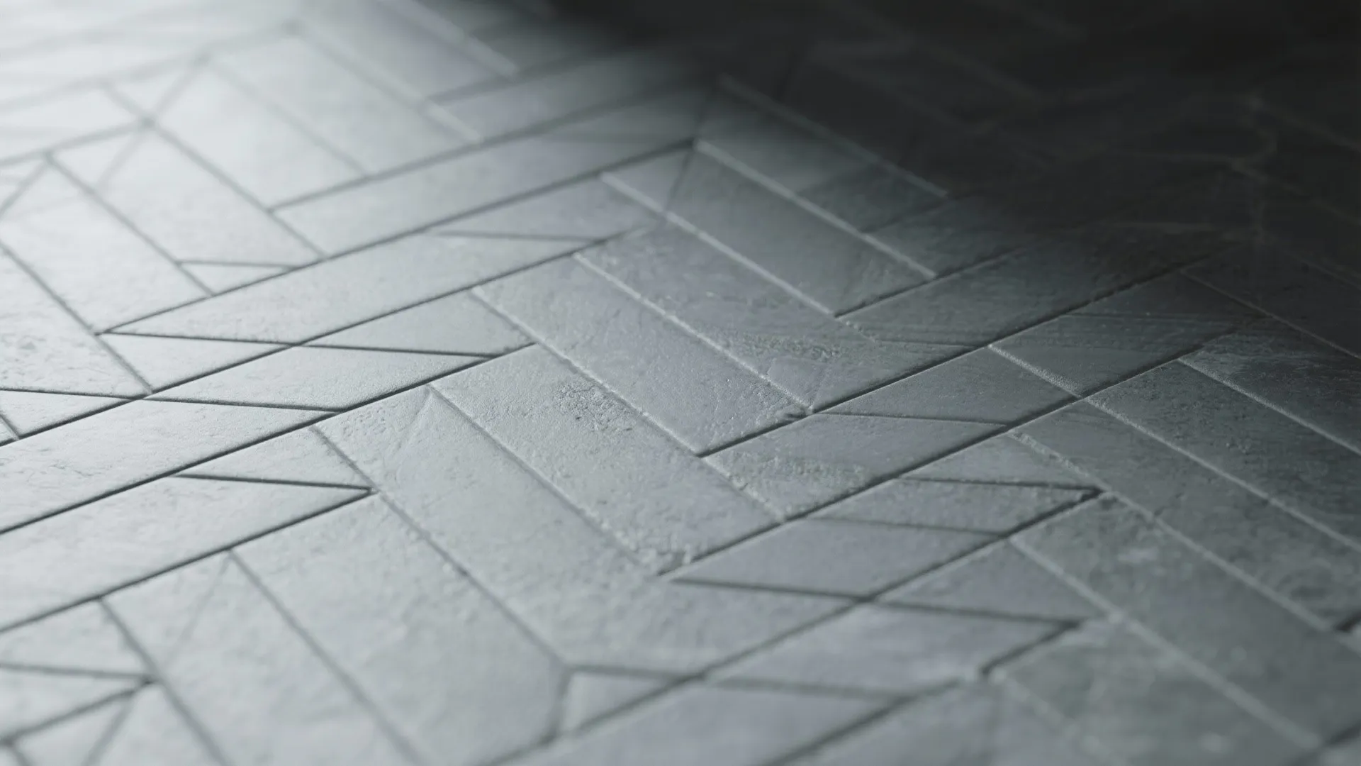 Close-up of grey matte floor tiles featuring a geometric pattern with natural lighting and shadows