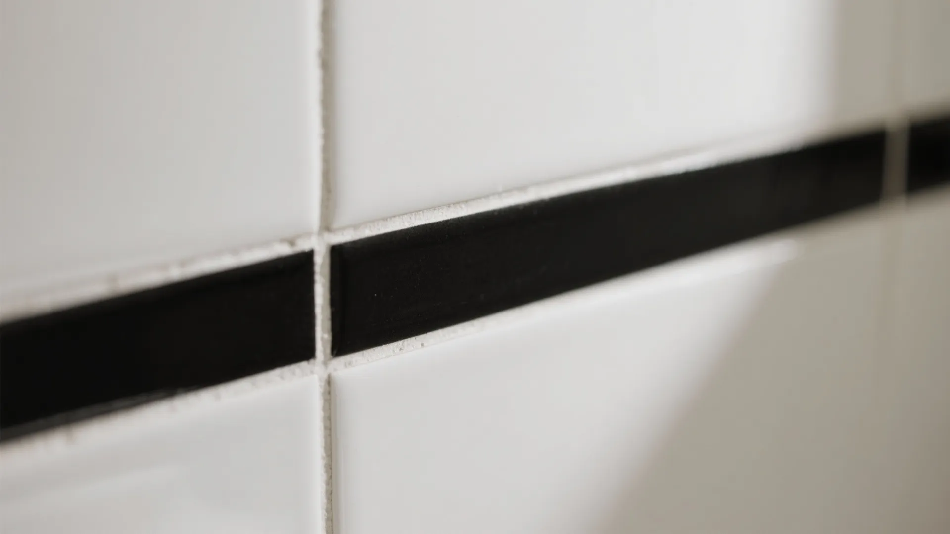 White square wall tiles with a horizontal black border line and thin white grout lines