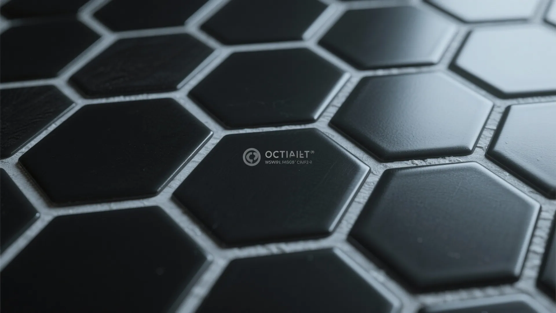 Close up view of black hexagon wall tiles with light grey grout in a bathroom