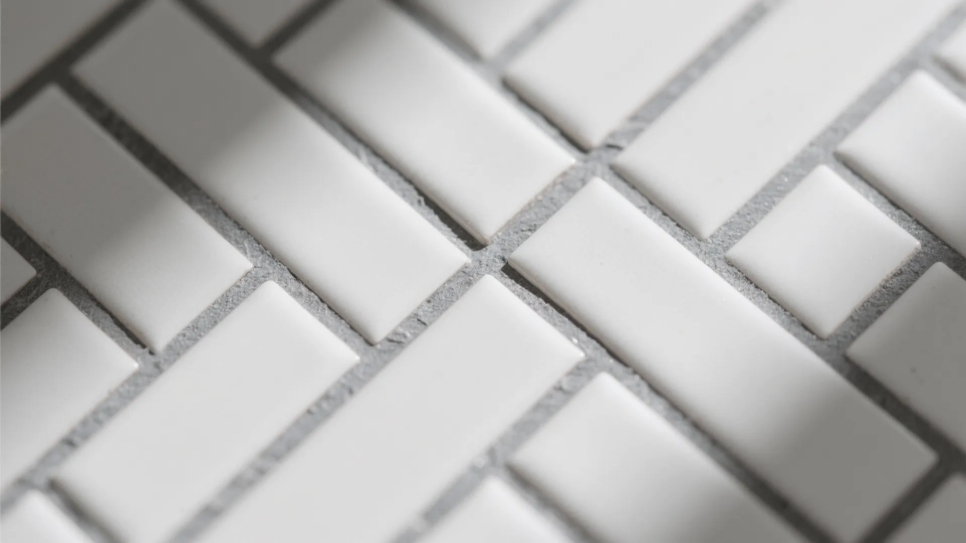 Close up view of white rectangular floor tiles with grey grout in a kitchen area