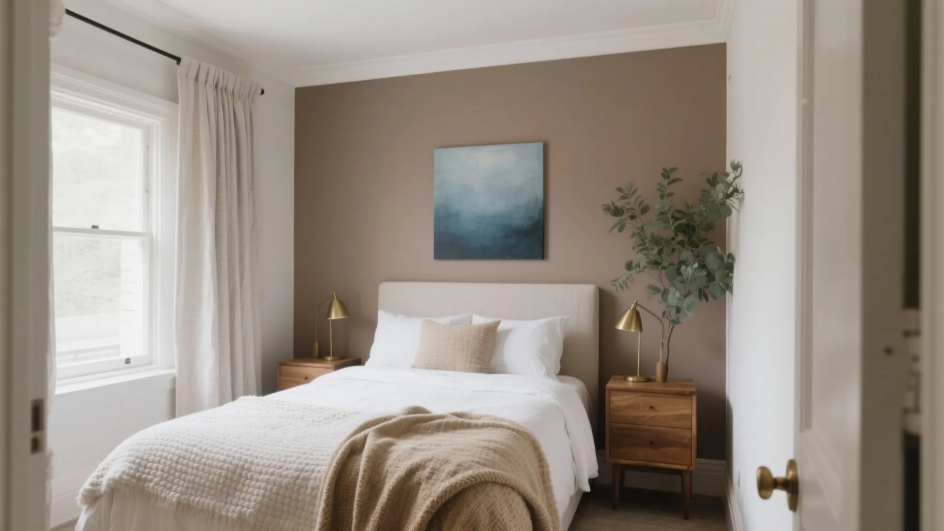 Cozy bedroom featuring brown accent wall blue painting white bed wooden nightstands and gold lamps