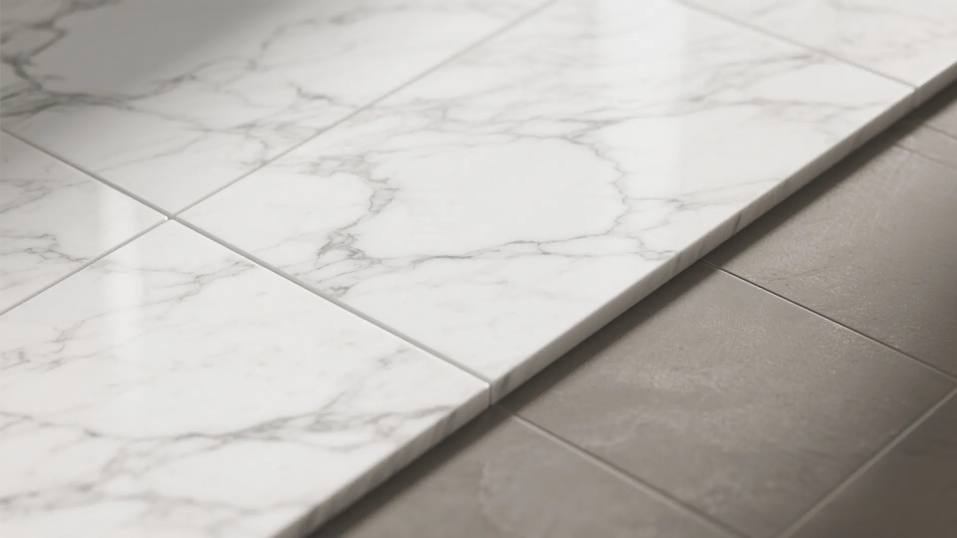Macro of veined white marble-look porcelain with tight grout next to warm grey floor.