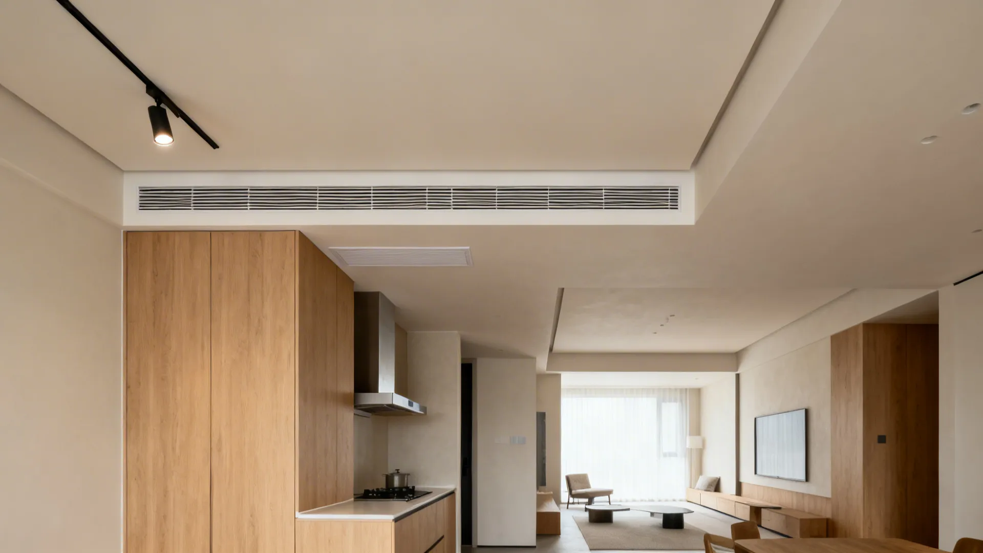 Open studio kitchen with a slim gypsum bulkhead aligning lights and hood, defining the zone cleanly.