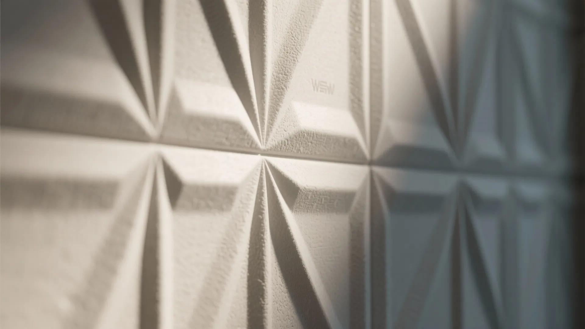 Close up view of white wall panel with geometric star patterns and textured surface finish