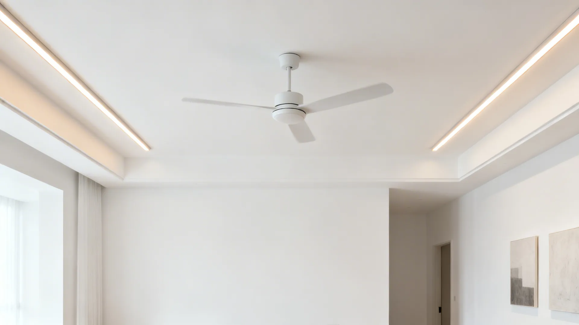 Minimalist living room with flat white gypsum ceiling and two linear lights placed outside the fan radius.