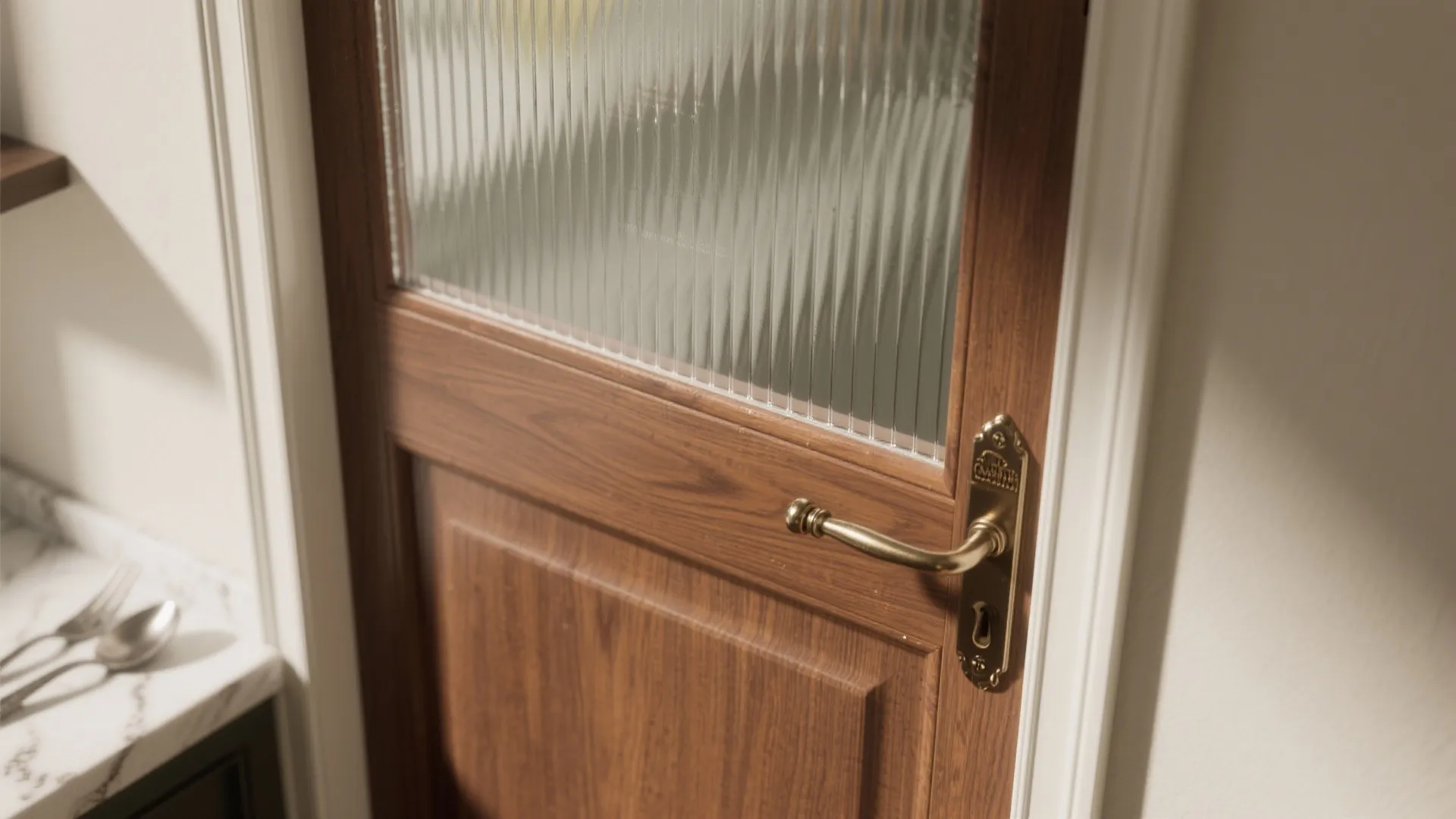 Close-up of a wooden interior door with glass panel and a gold metal handle design