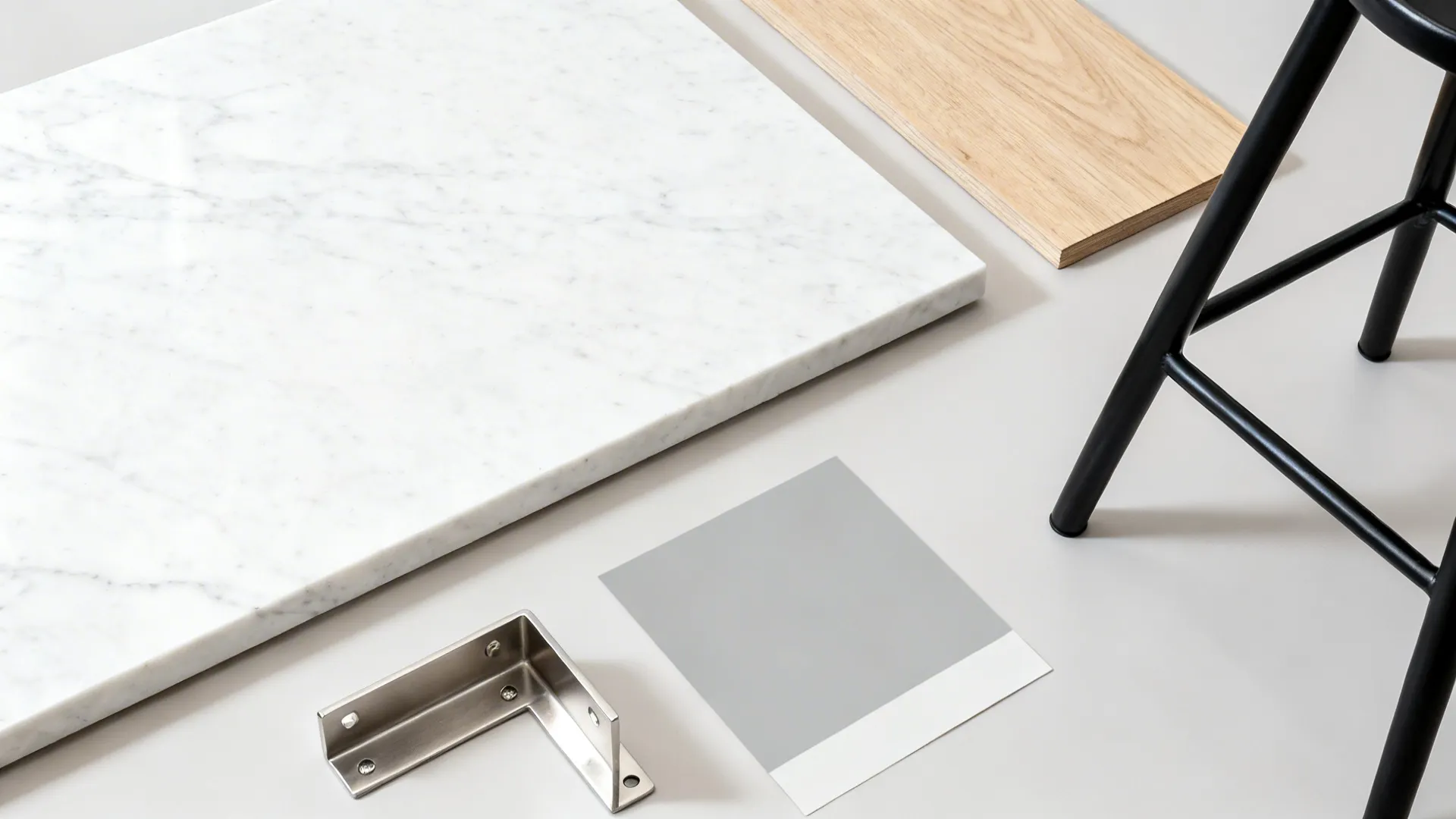 Interior design material flatlay featuring white marble slab wood sample grey swatch and metal hardware