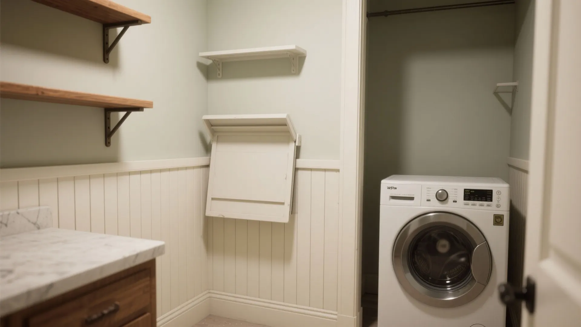 Small laundry room with white wall panel wooden shelves washing machine and folding wall table