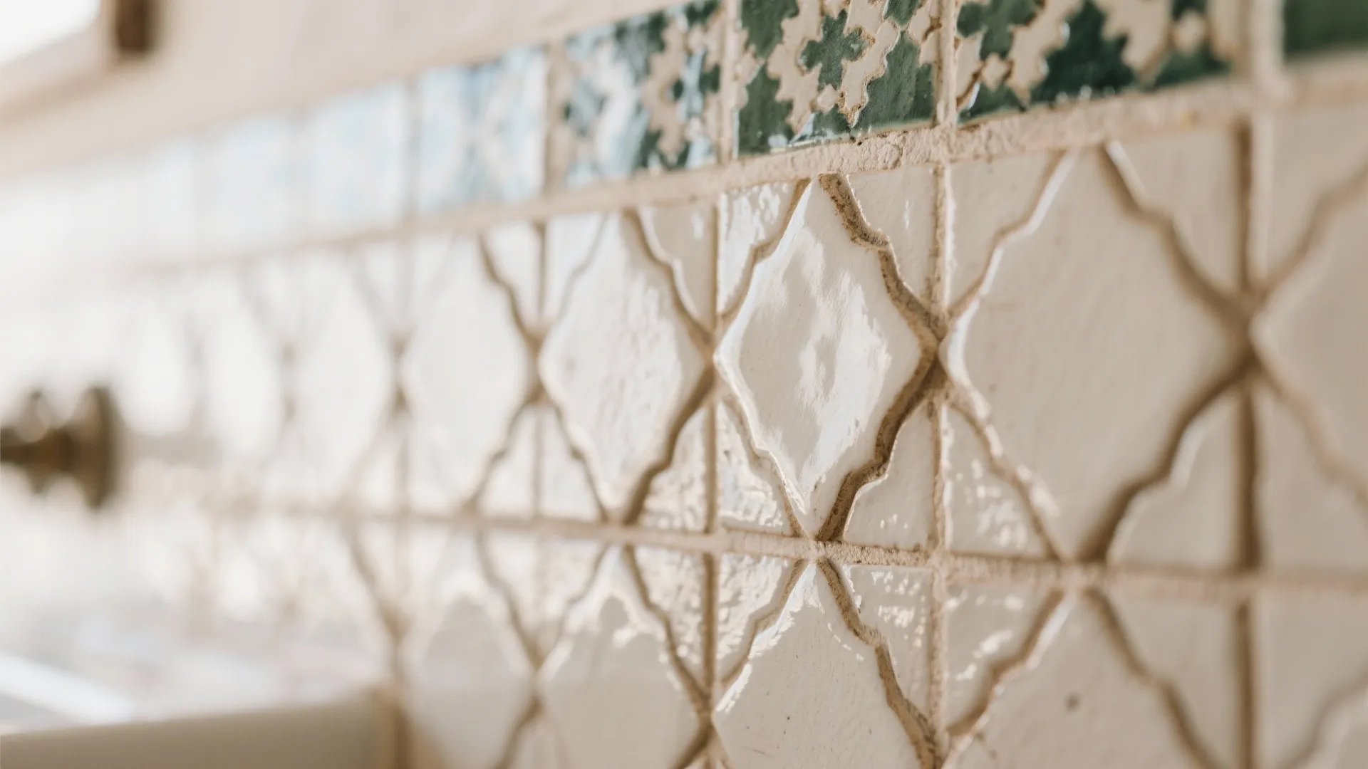 Close up of decorative white wall tiles with diamond shapes and green patterned tile details