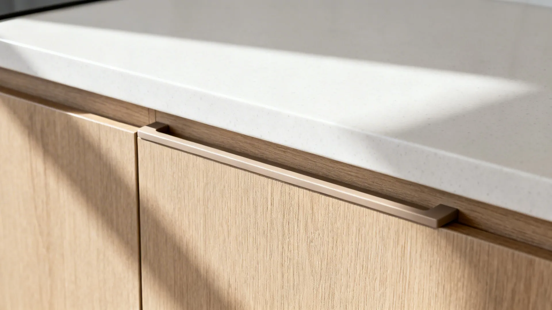 Close-up of a handleless cabinet with integrated pull and soft-matte finish in a modern U-shaped kitchen.
