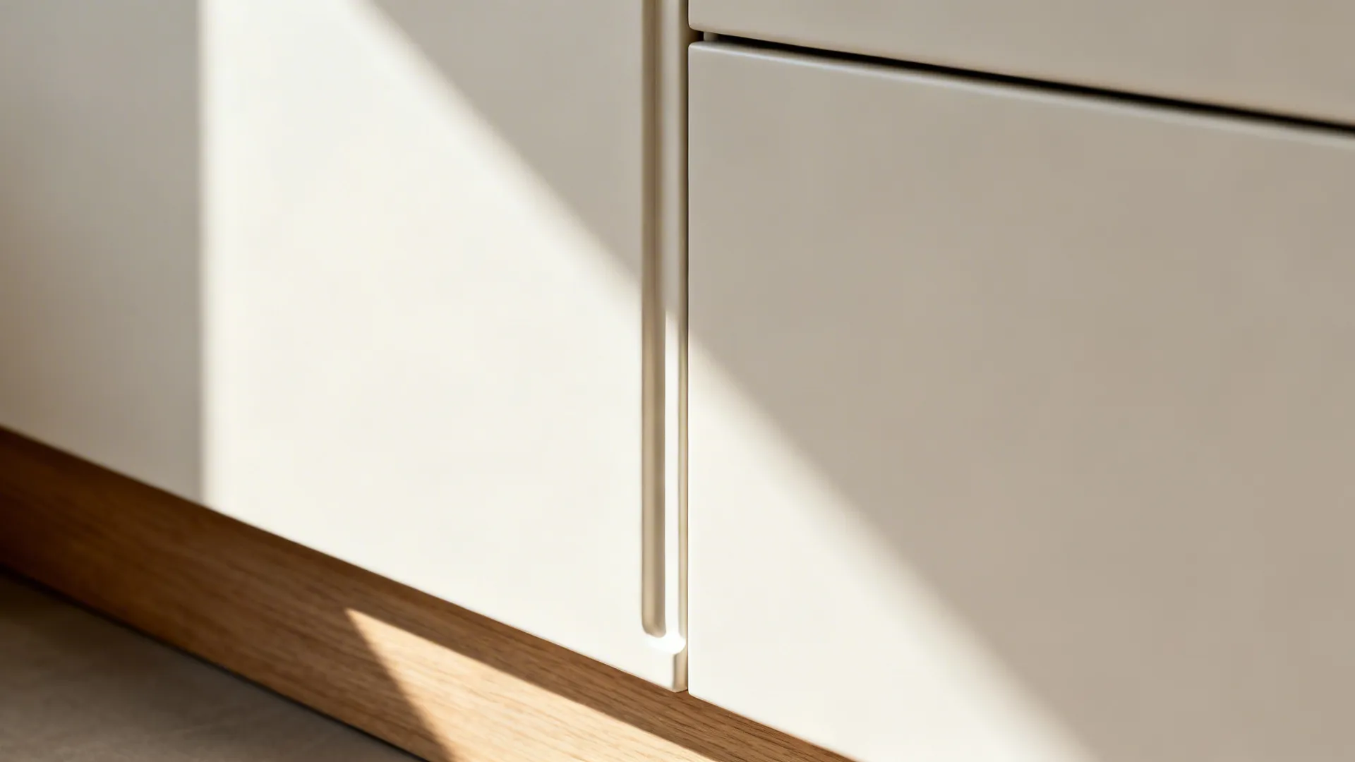 Macro detail of handleless matte cabinet pull with precise shadow line in a minimalist kitchen.