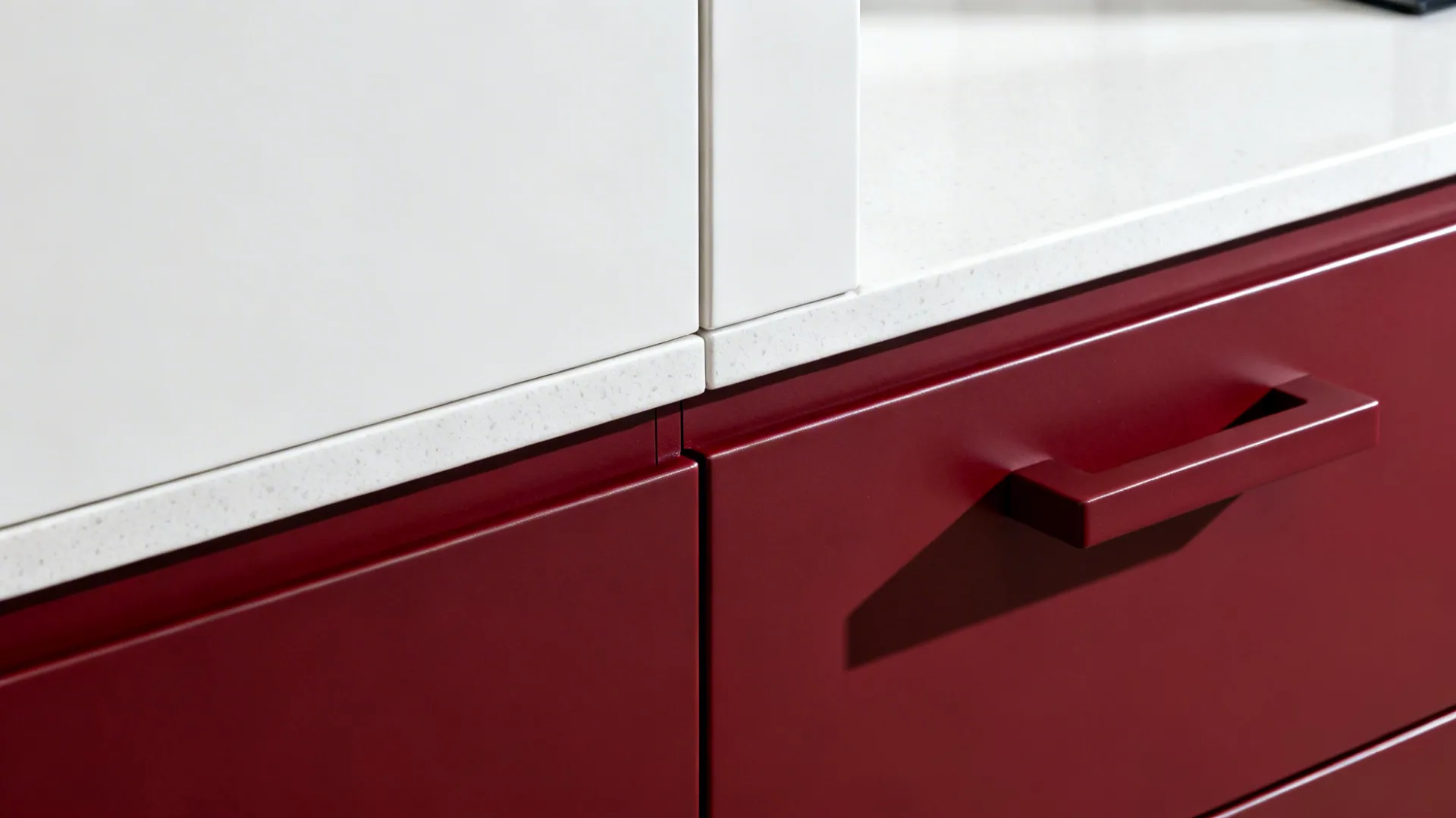 Macro detail of handleless matte white upper and cherry-red lower cabinet junction.
