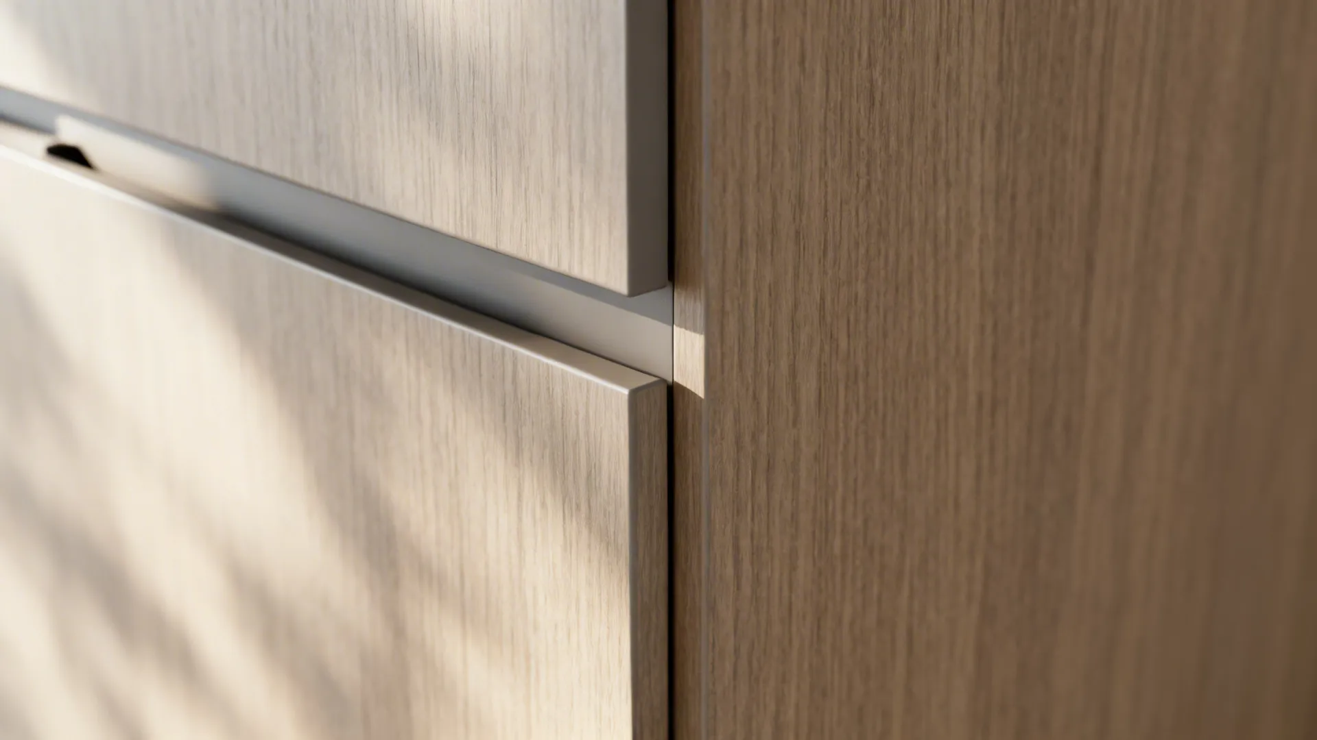 Close-up of a handleless cabinet edge with a slim shadow gap and matte finish.