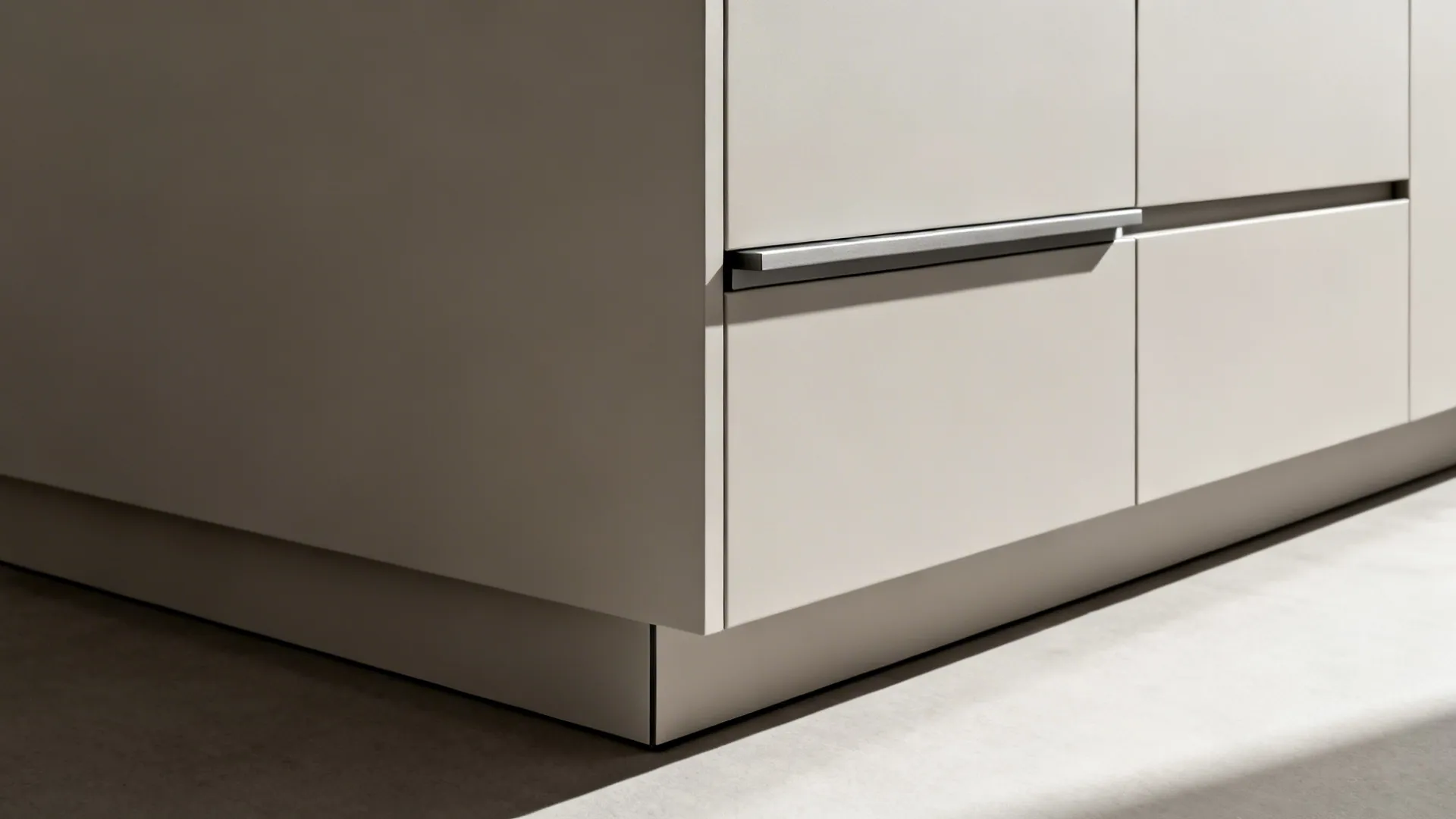 Macro of ultra-matte handleless cabinet with a crisp shadow-line toe-kick.