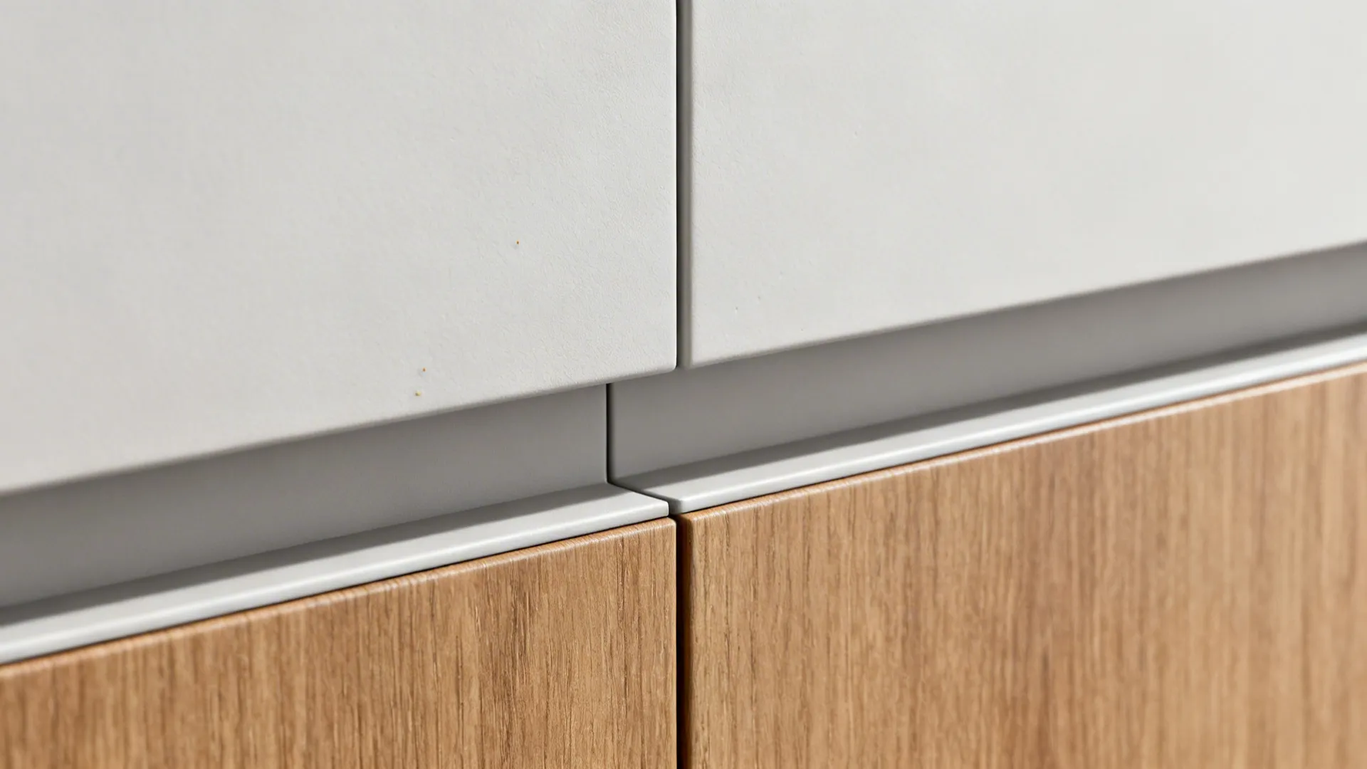 Macro of a handleless kitchen cabinet channel showing clean matte finish and subtle groove.