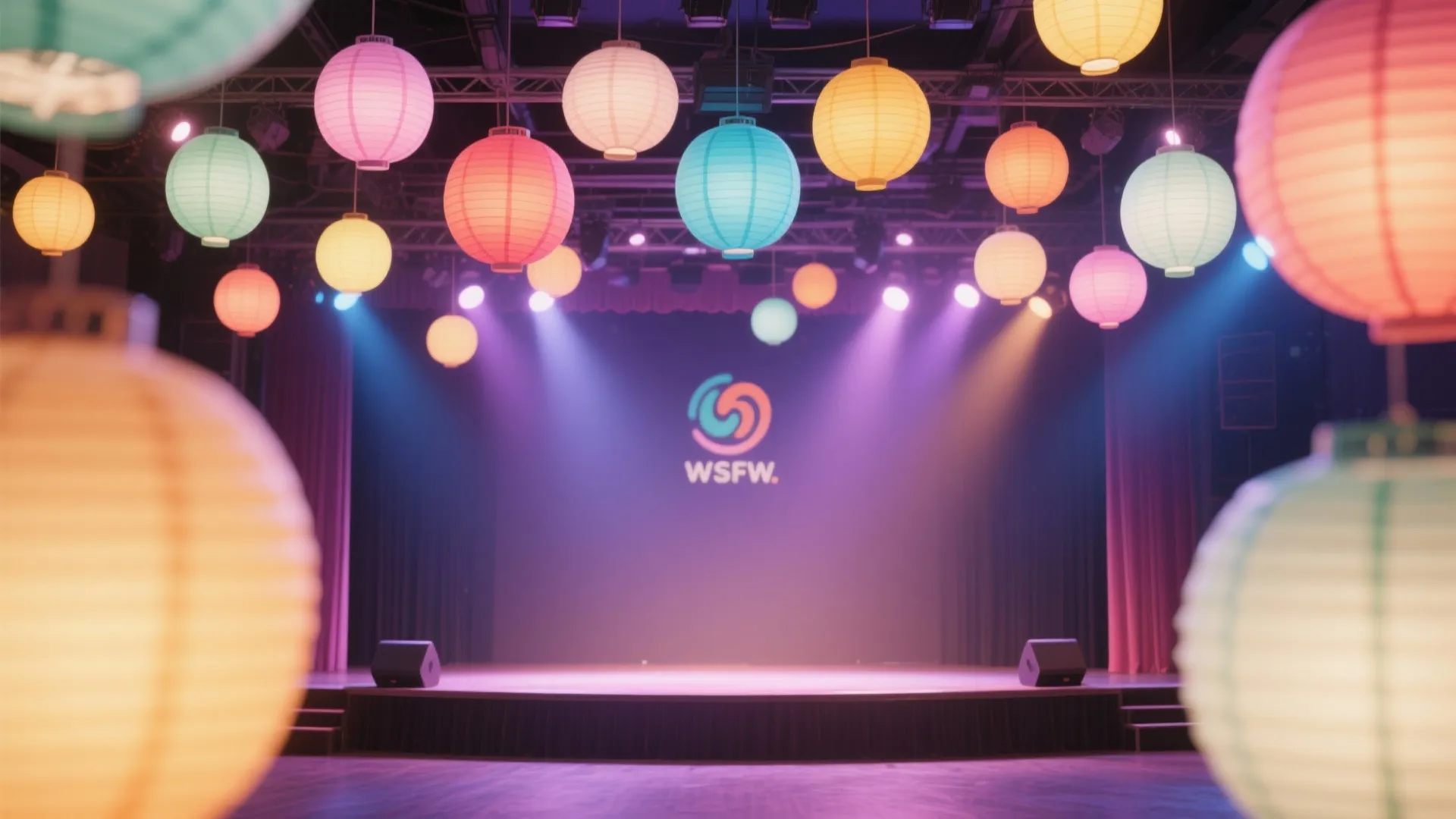 Colorful round paper lanterns hanging from a ceiling above a stage with purple spotlight beams