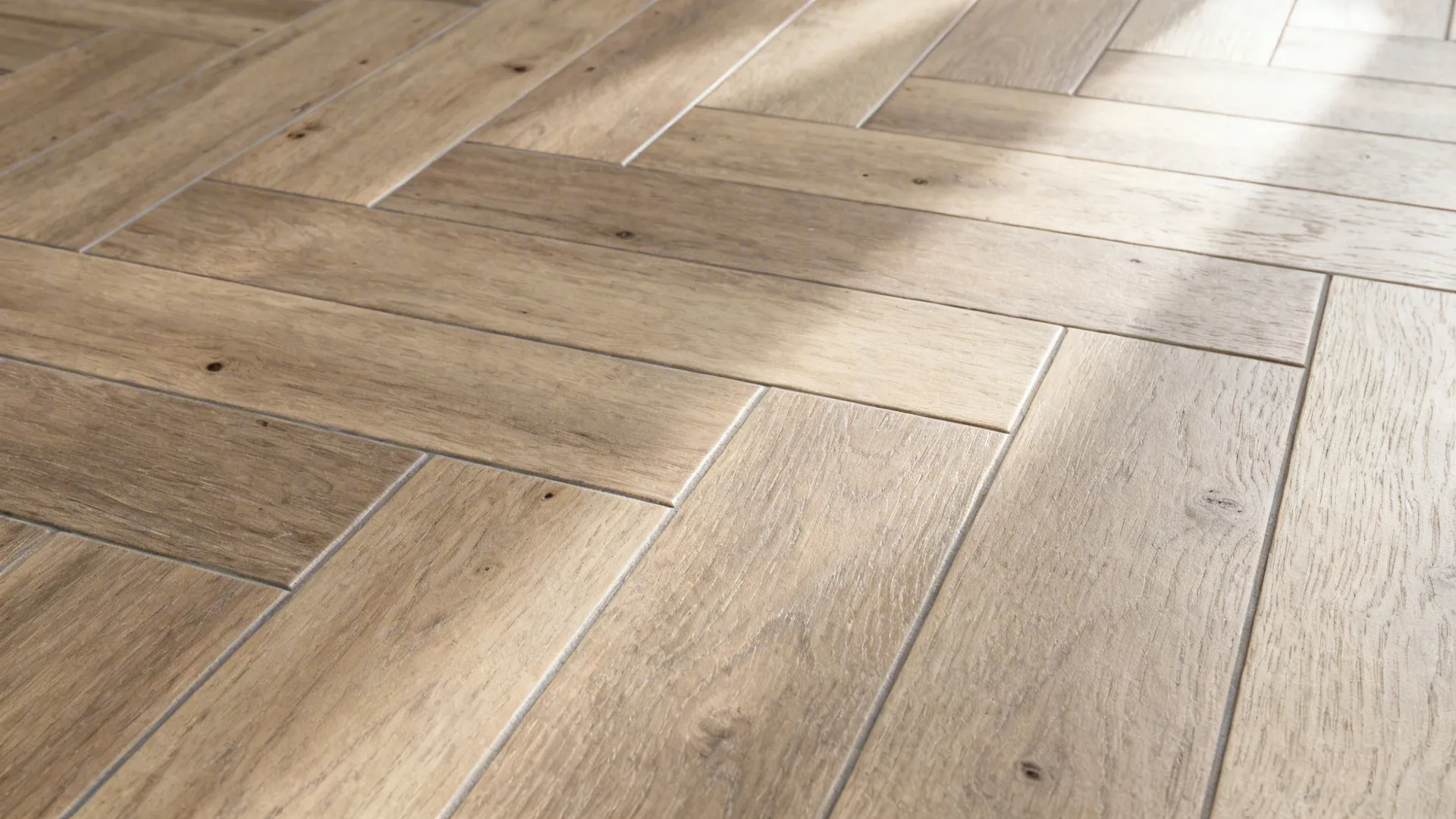 Macro of herringbone wood-look porcelain showing tight joint and natural grain.