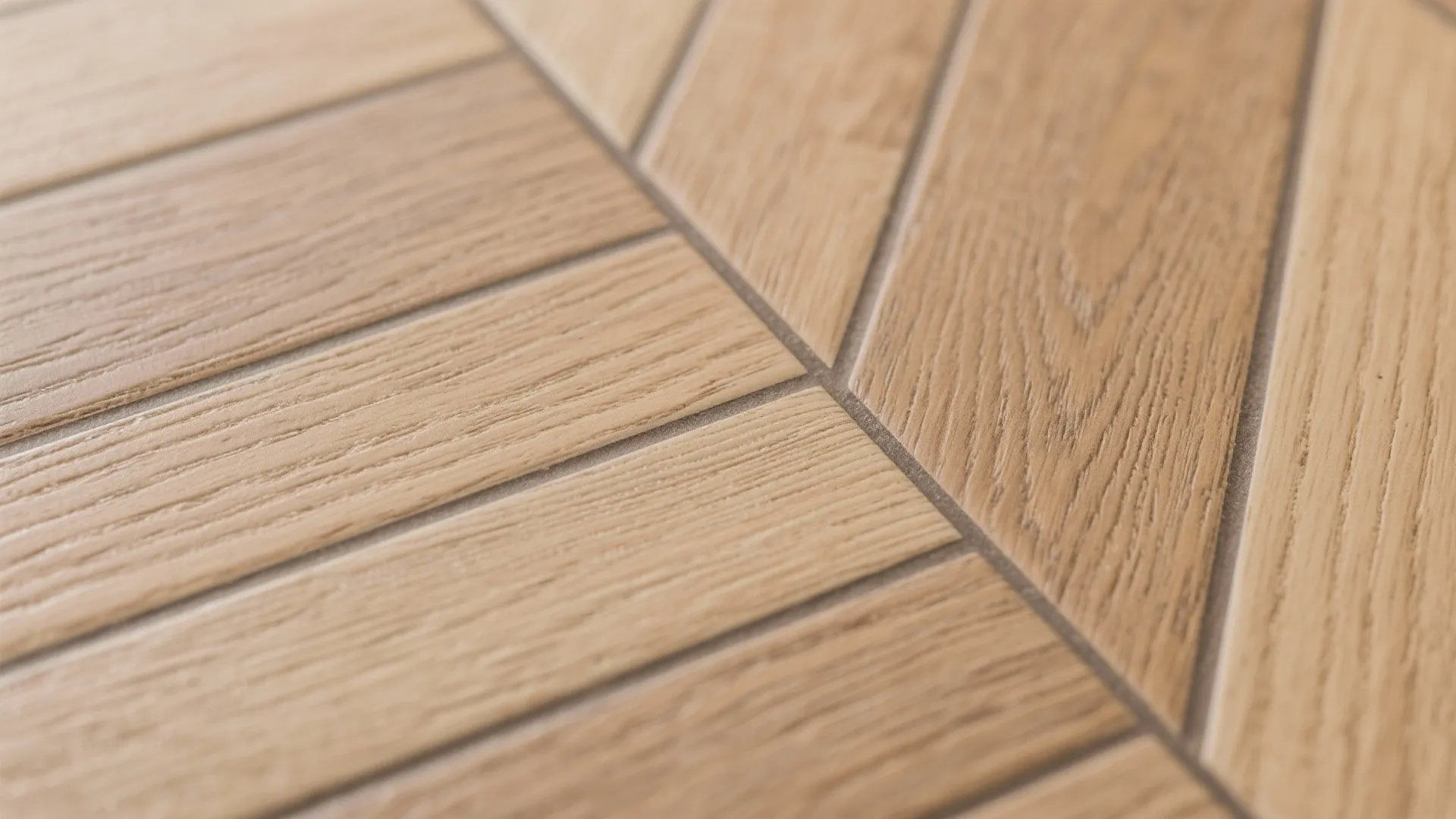 Close up of light brown wood floor tiles arranged in a clean zigzag pattern with lines