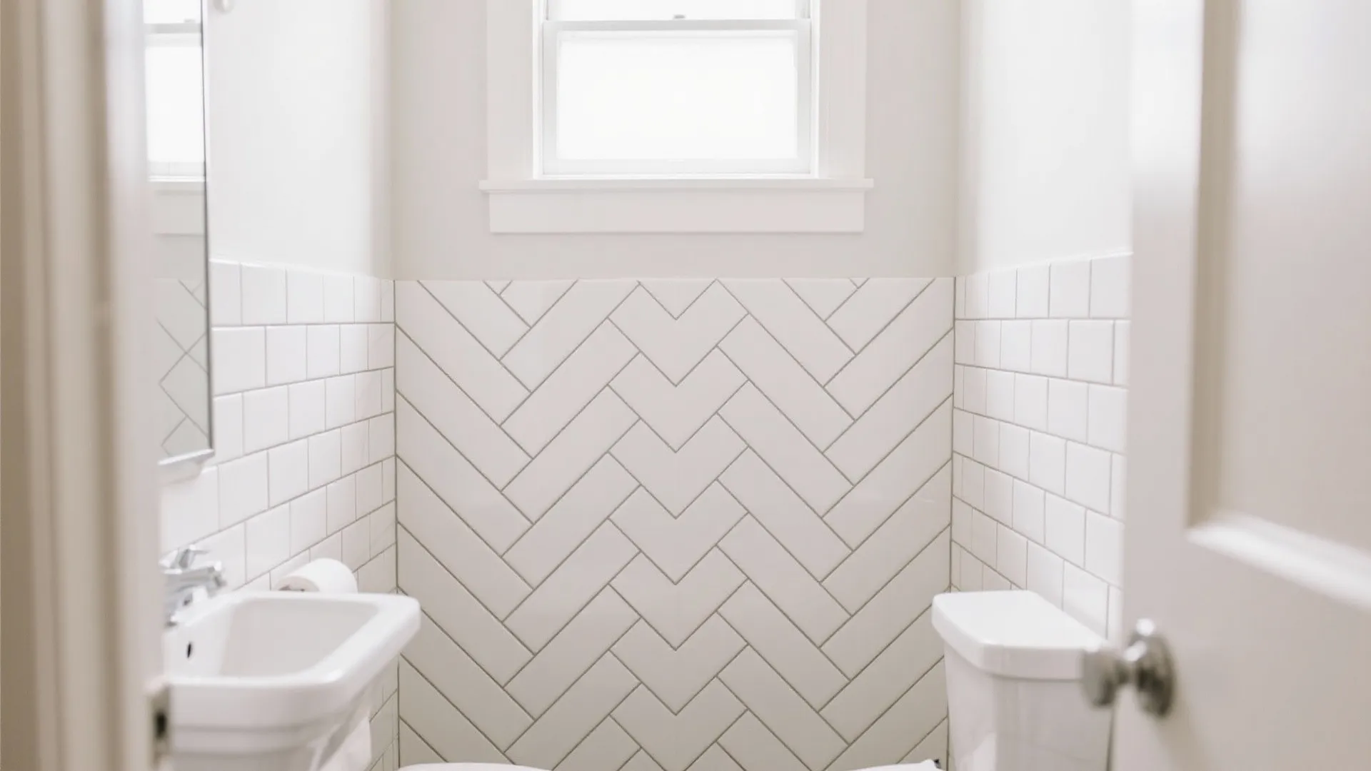 Small white bathroom featuring herringbone tile pattern on wall small sink window and bright light