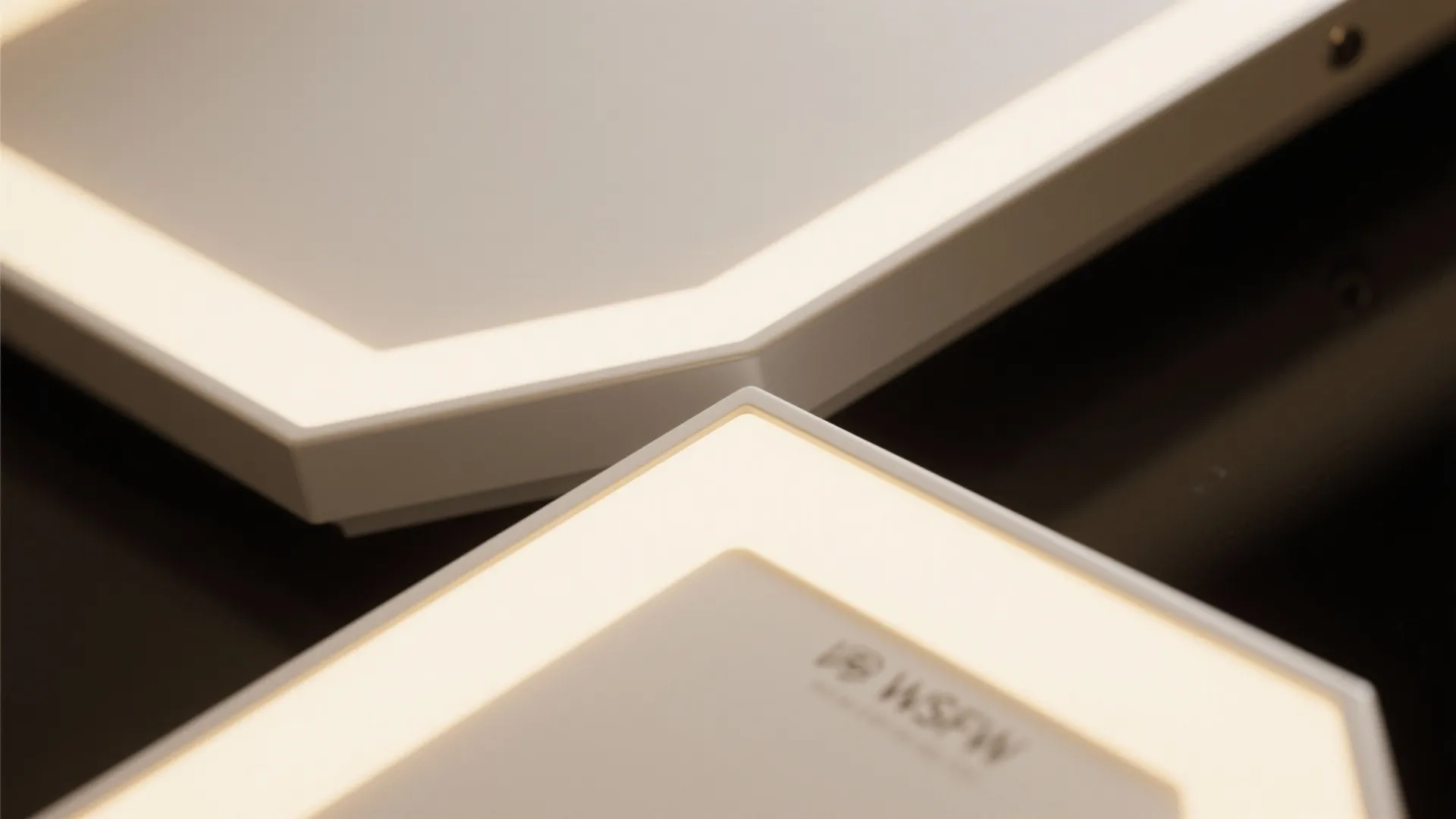 Close up of hexagonal light fixture panels with bright white glowing edges on dark background
