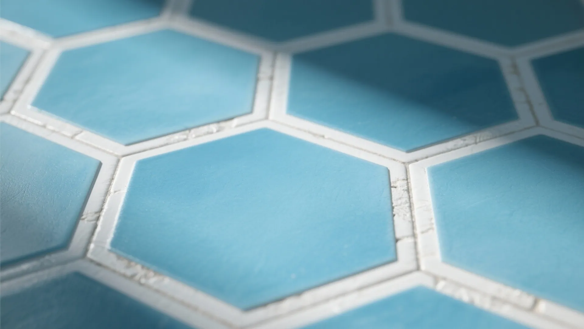 Close-up of sky-blue hexagon tiles with white grout showing texture and vintage-modern feel.
