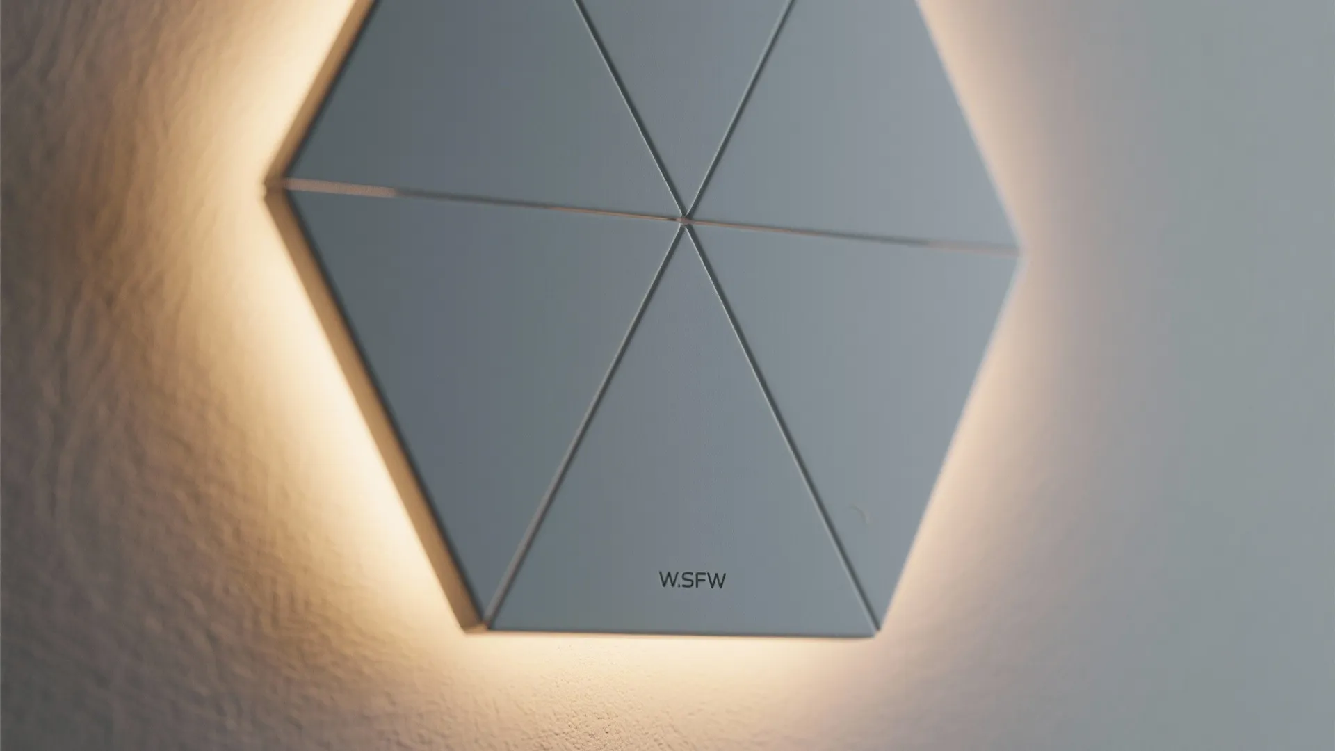 Macro of a hexagon wall light showing matte diffuser texture and warm glow.