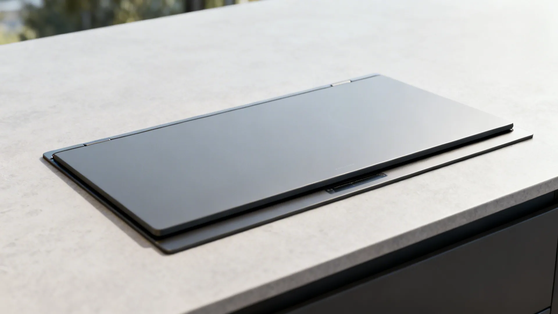 Close-up of a flush induction cooktop covered by a matching countertop insert for a seamless island