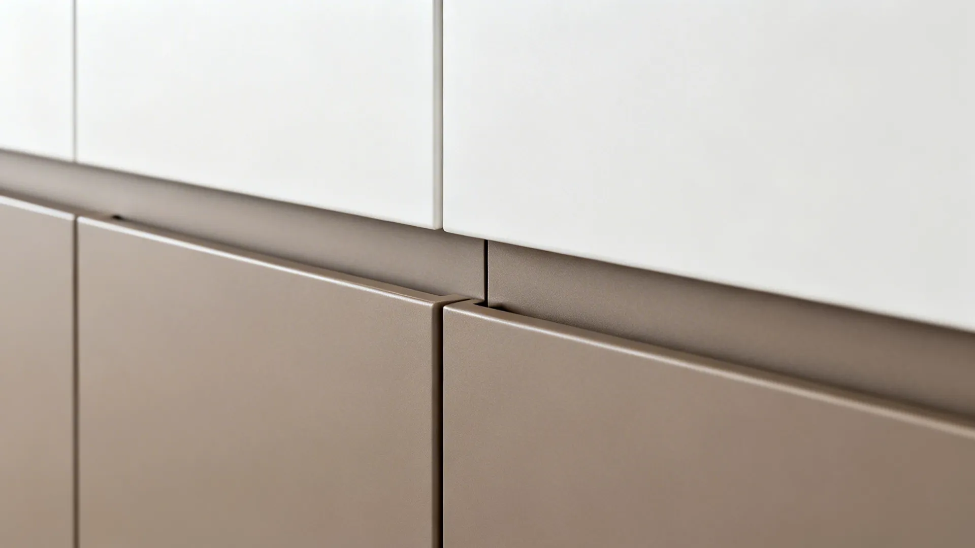Close-up of handleless slab-front kitchen cabinet with integrated pull channel under soft daylight.