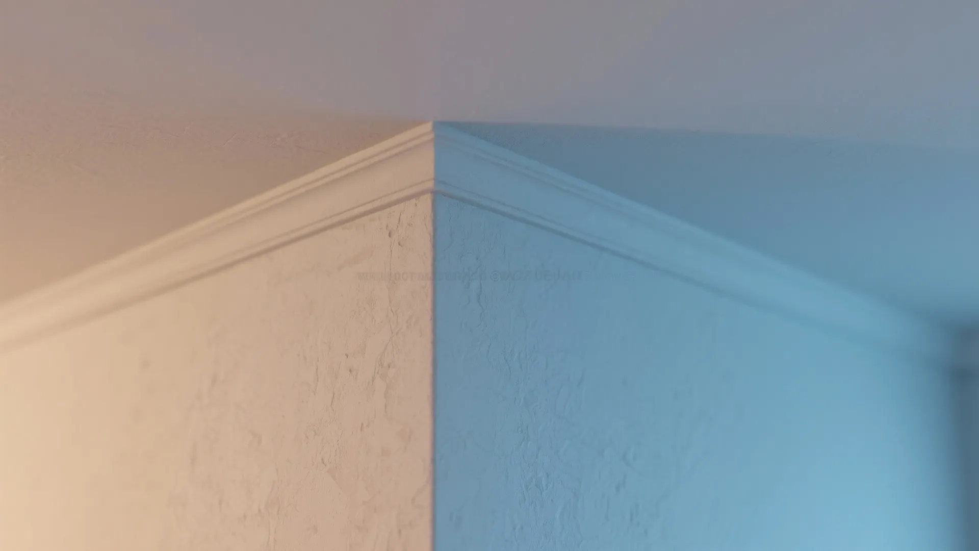 Close-up of a seamless wall-to-ceiling junction painted the same color, masking uneven trim and lines.