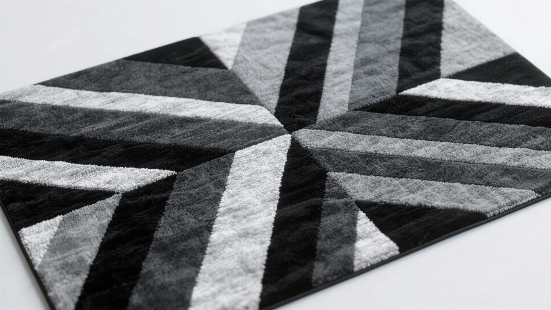 Soft floor rug with a geometric star pattern in black grey and white color tones