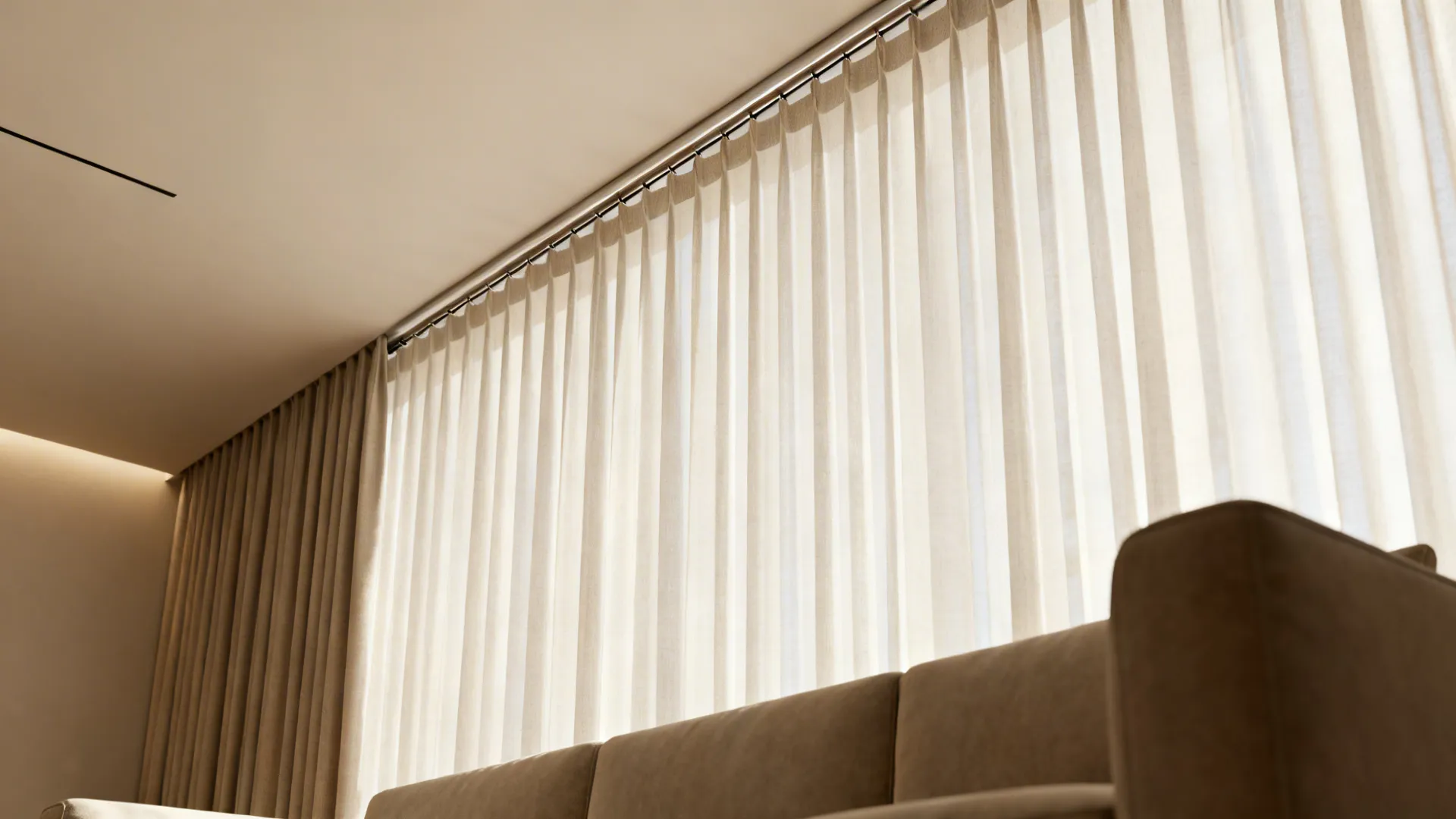 High-mounted slim sheers above a sofa creating a taller visual ceiling