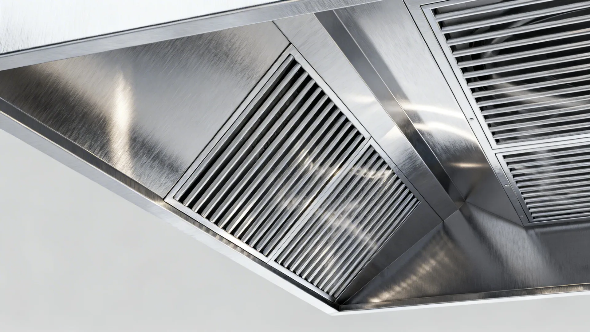 Macro of stainless hood baffle filters with a nearby make-up air diffuser.