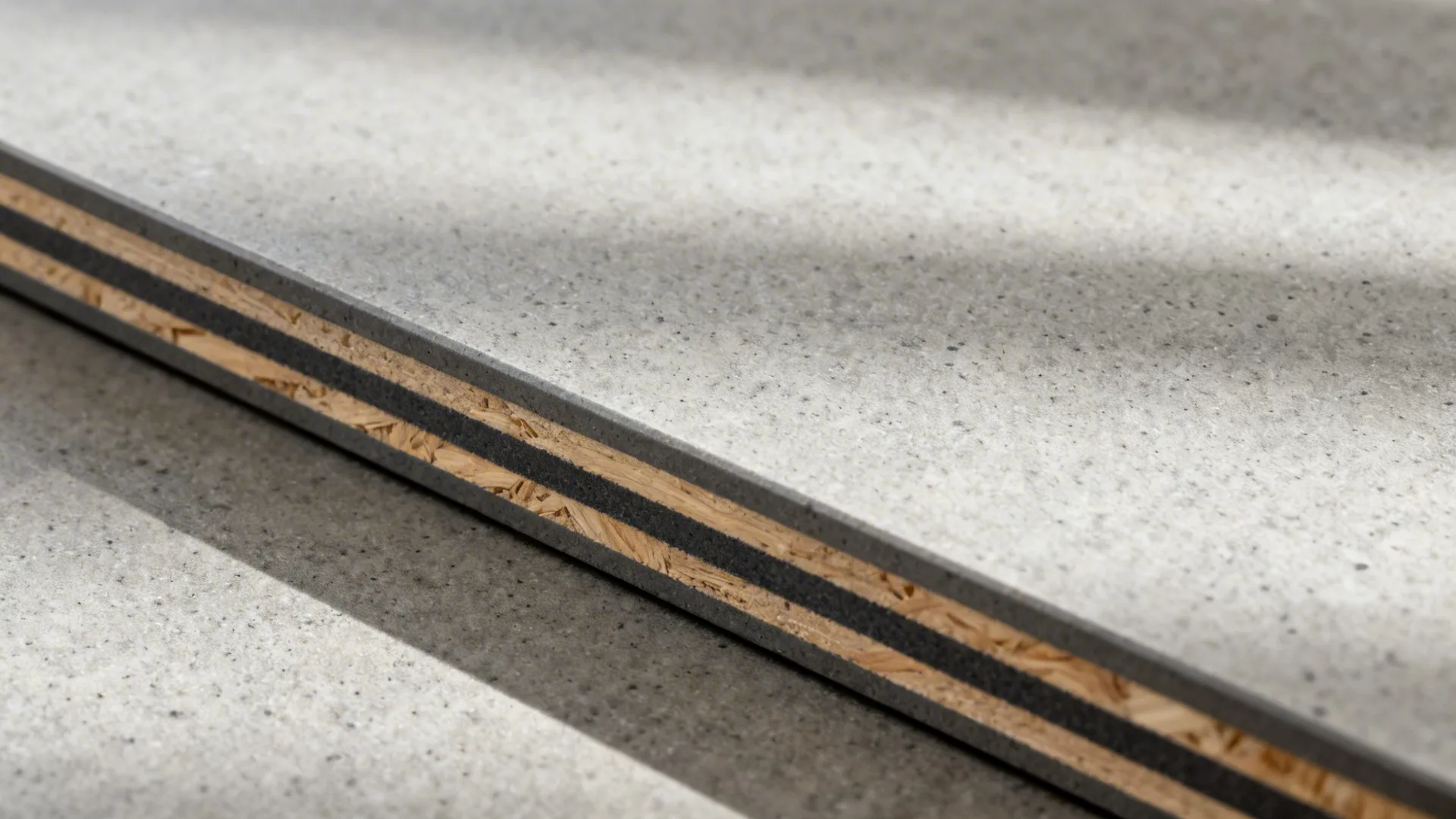 Macro of concrete-look HPL laminate with smooth post-formed front edge.