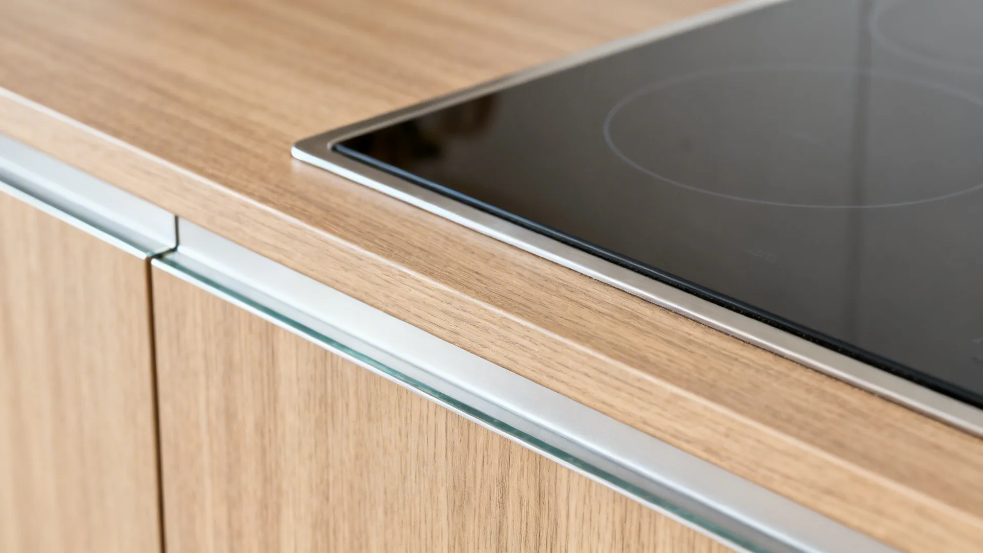 Close-up of wood-look laminate with neat edge banding and protective skirting near the hob.