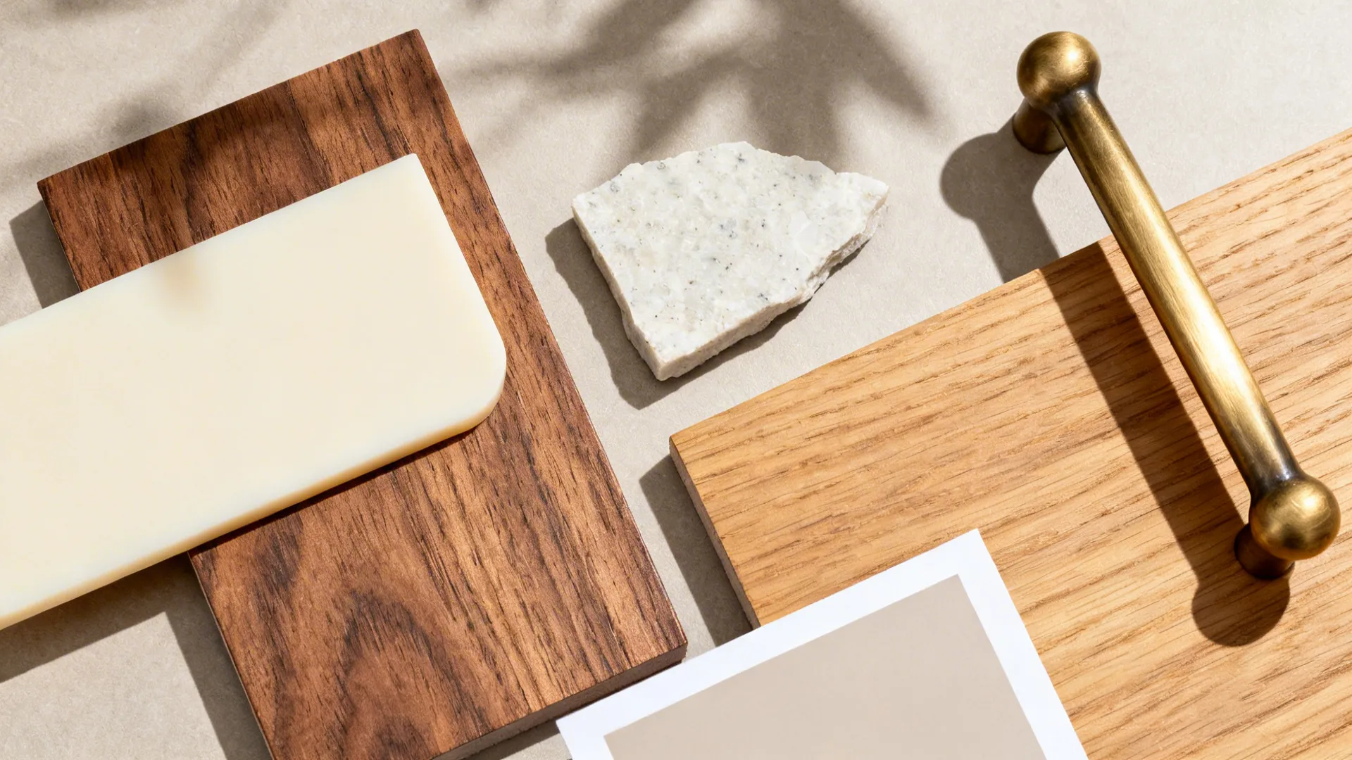 Flat lay with matte cream acrylic, oak and walnut veneers, quartz, and brass pull.