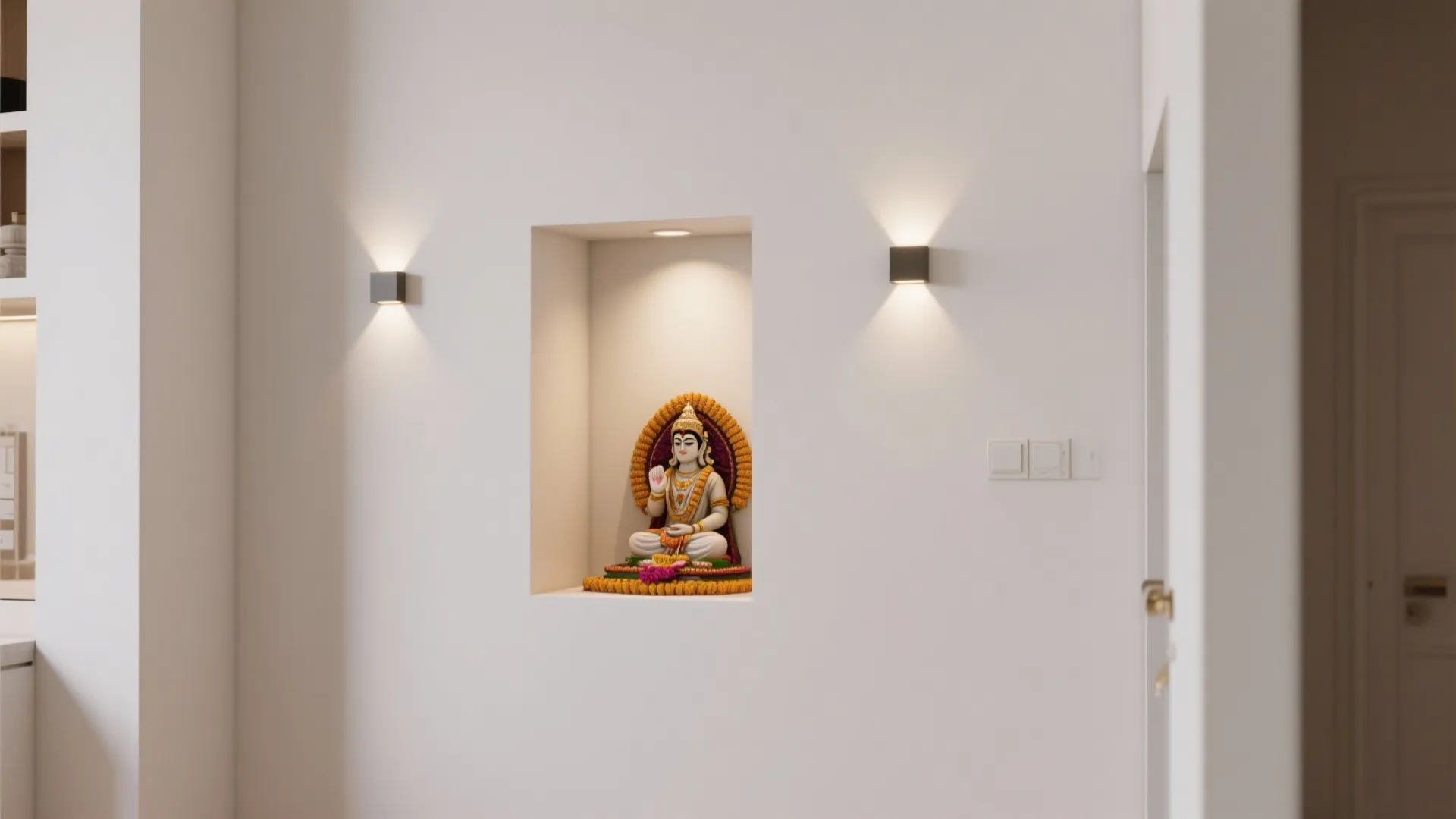 White wall niche showing a religious statue with two small wall lights on a background