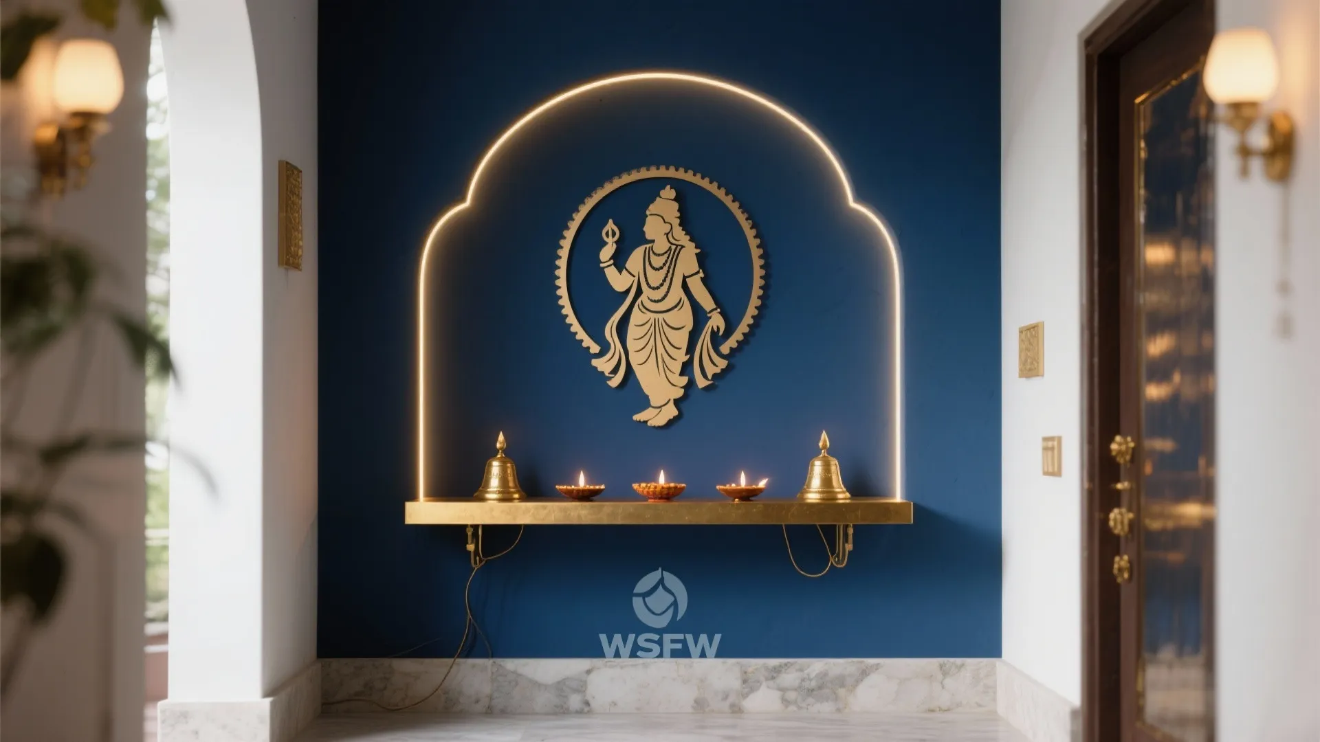 Blue prayer room wall with golden figure decoration lit by an arch shaped light fixture