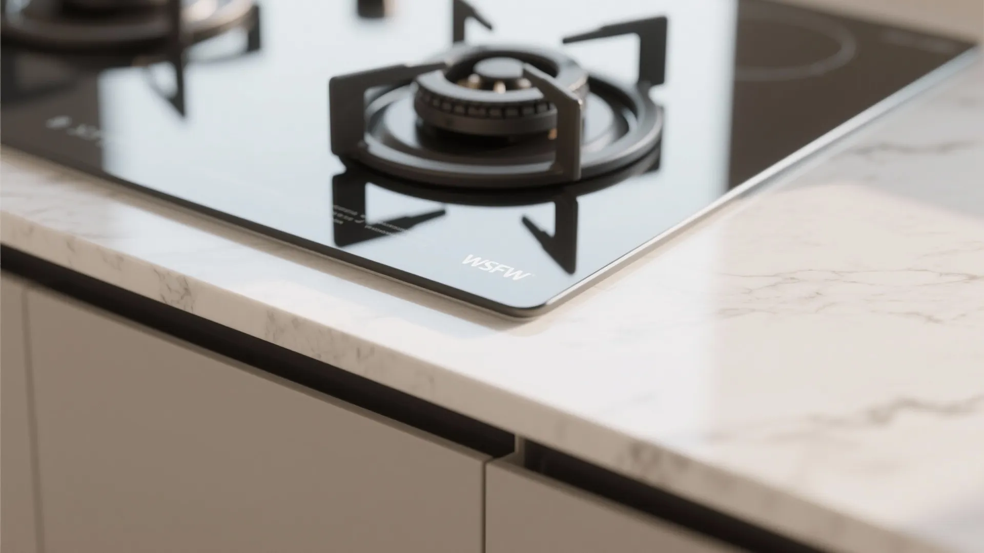 Black gas stove burner on white marble countertop with modern kitchen cabinets and bright indoor light