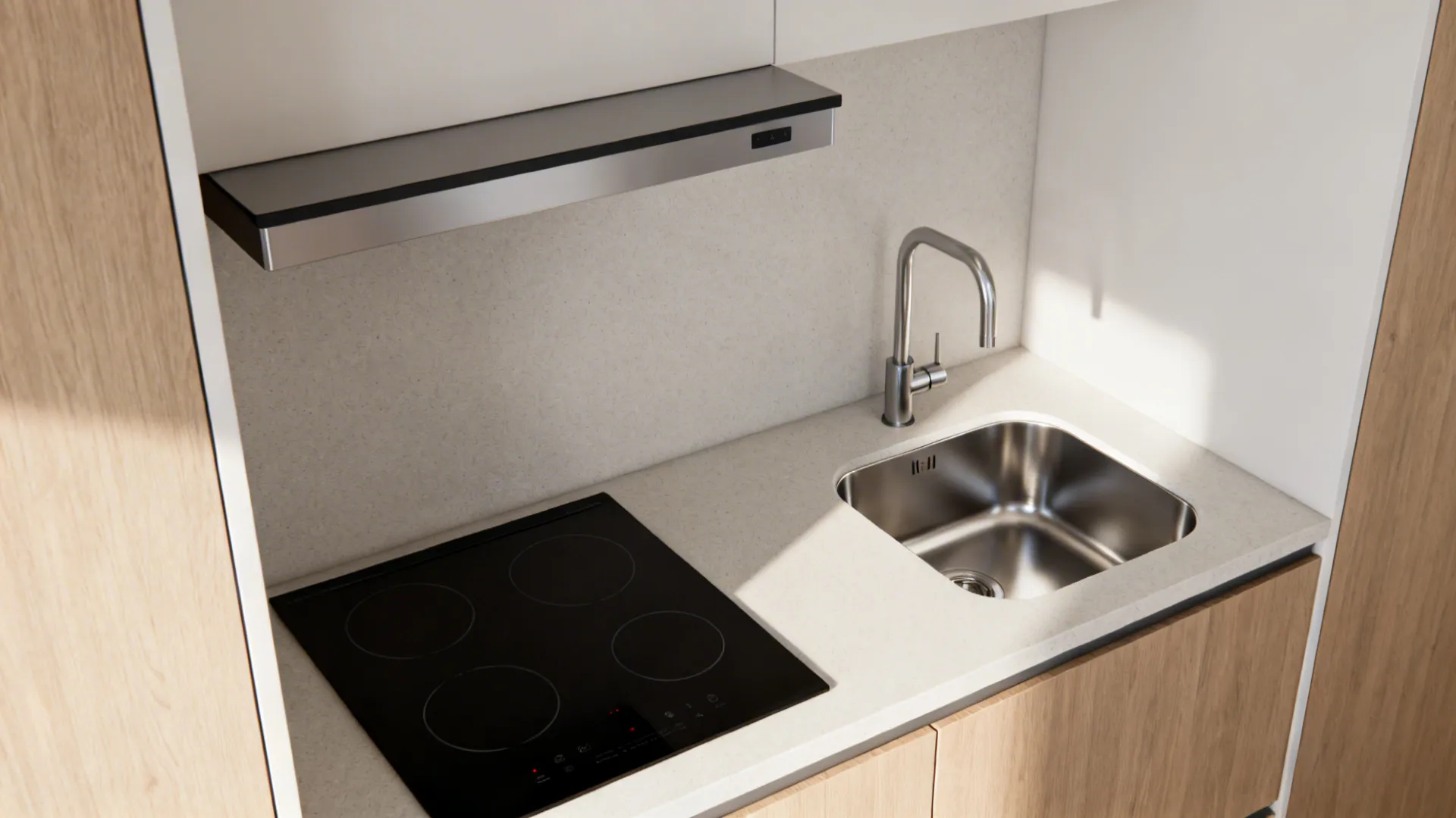 Black electric stove and stainless steel sink built into a light stone kitchen work top