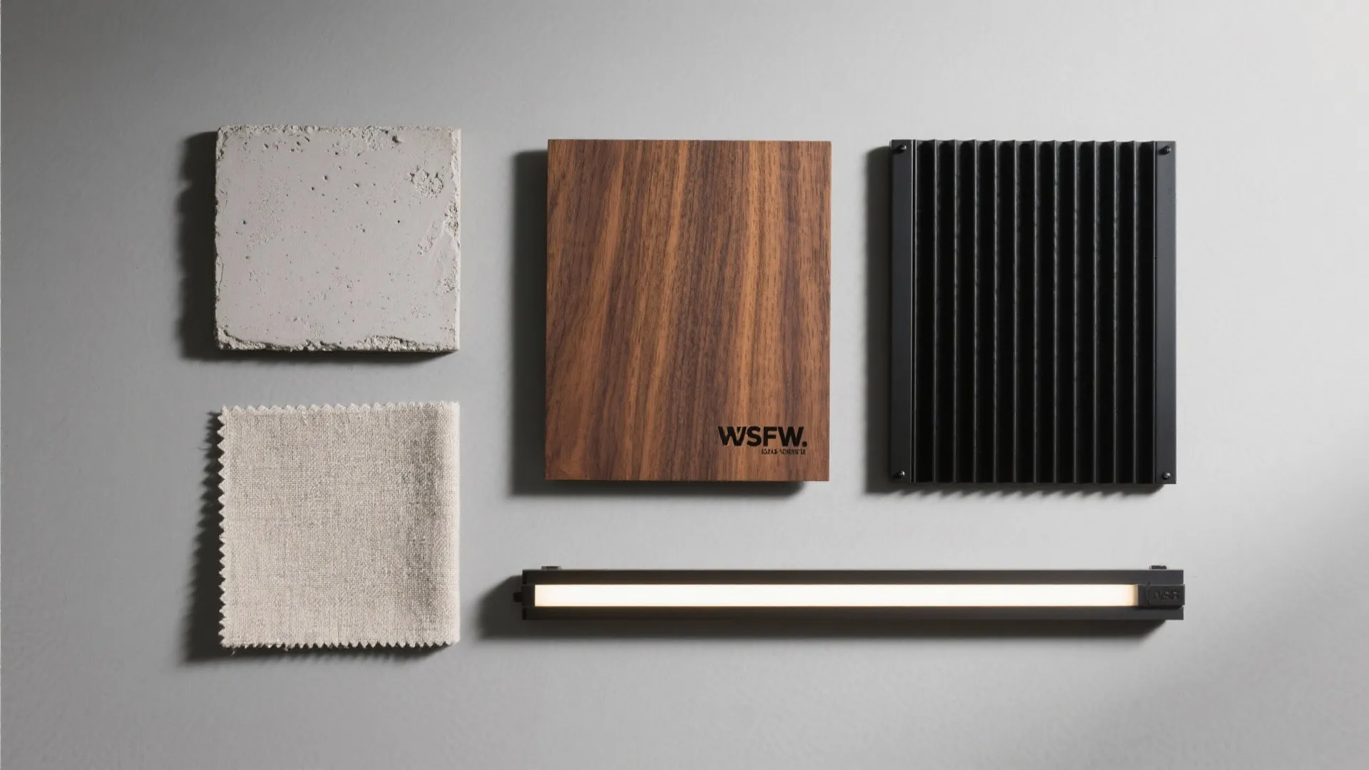 Flat lay of microcement, walnut veneer, matte black metal, LED strip, and fabric swatch.