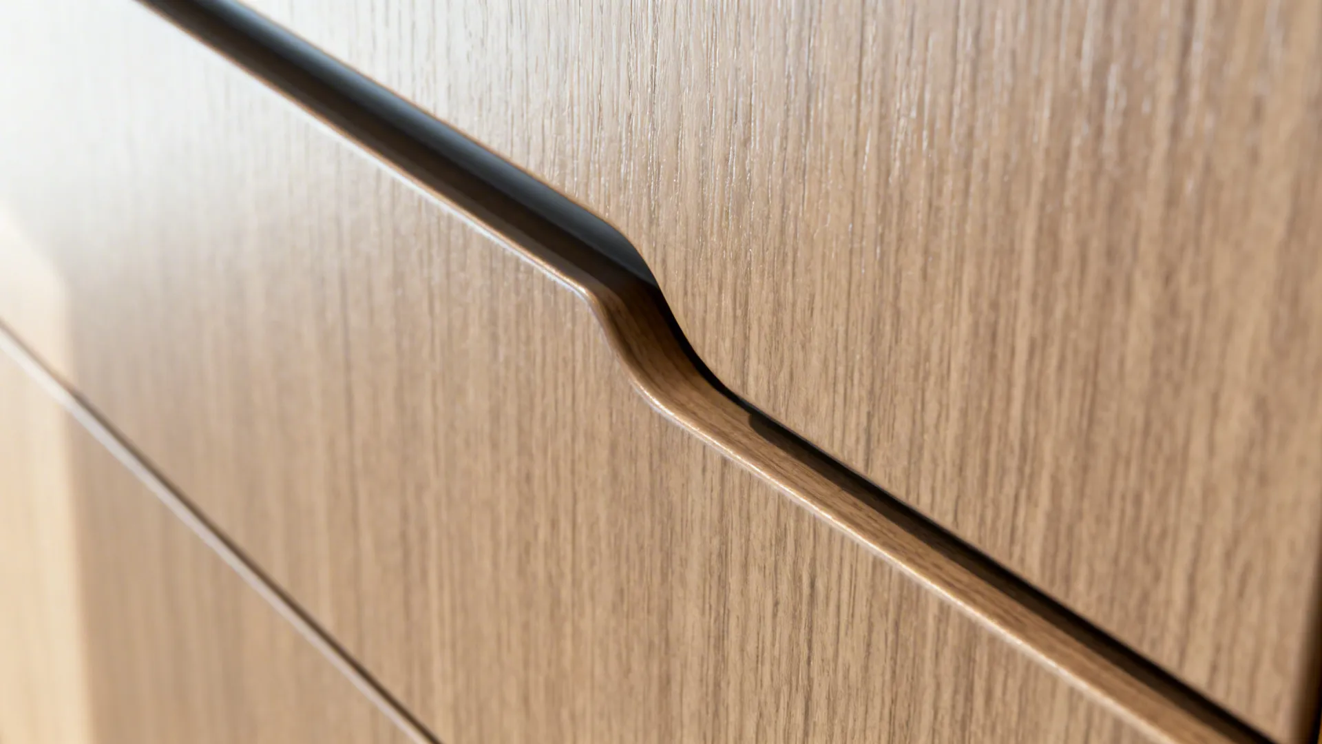Close-up of a satin laminate cabinet with an integrated J-pull channel and clean alignment.