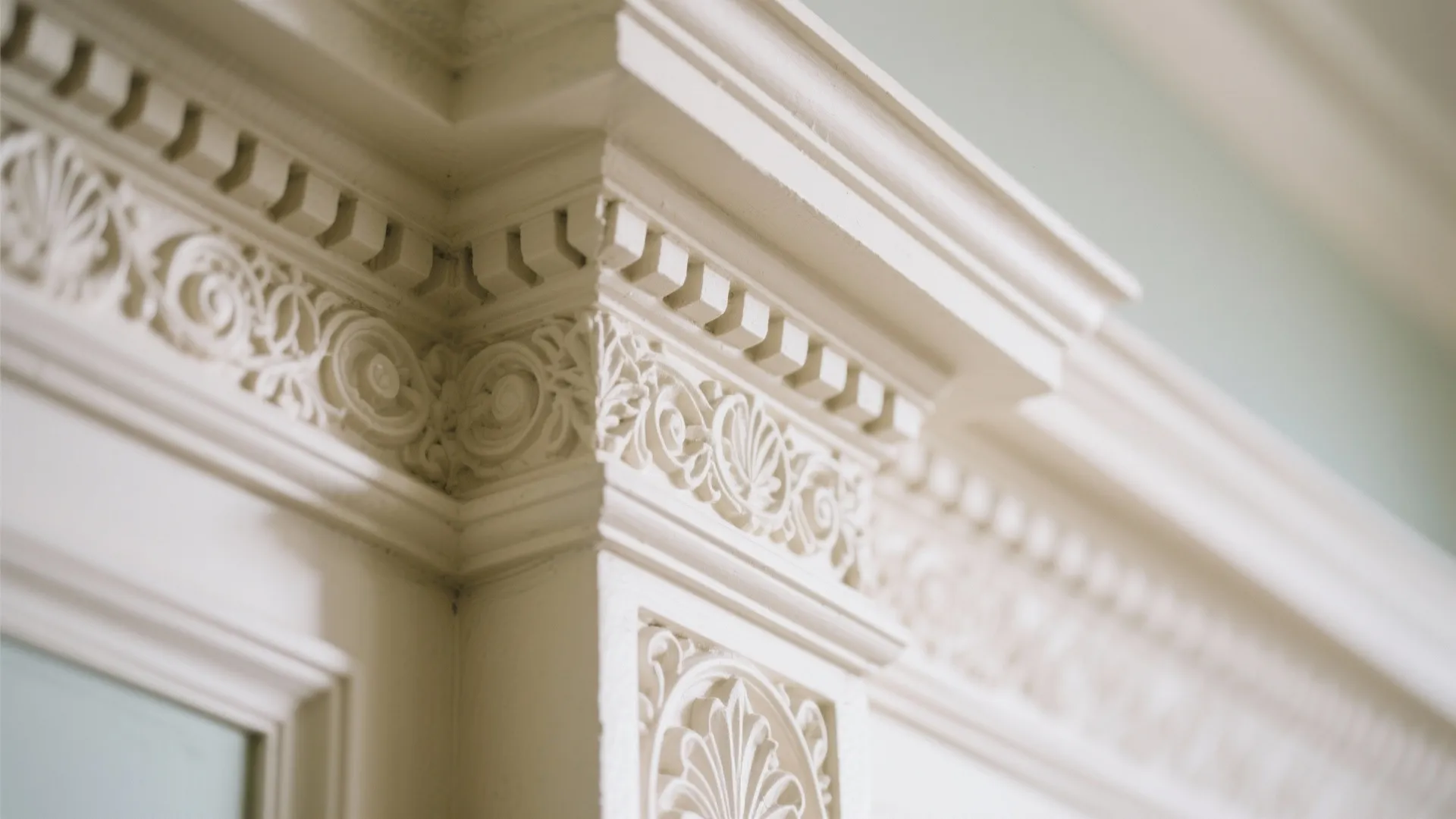 Close up of white decorative wall panel and ceiling trim with detailed carvings in classic room