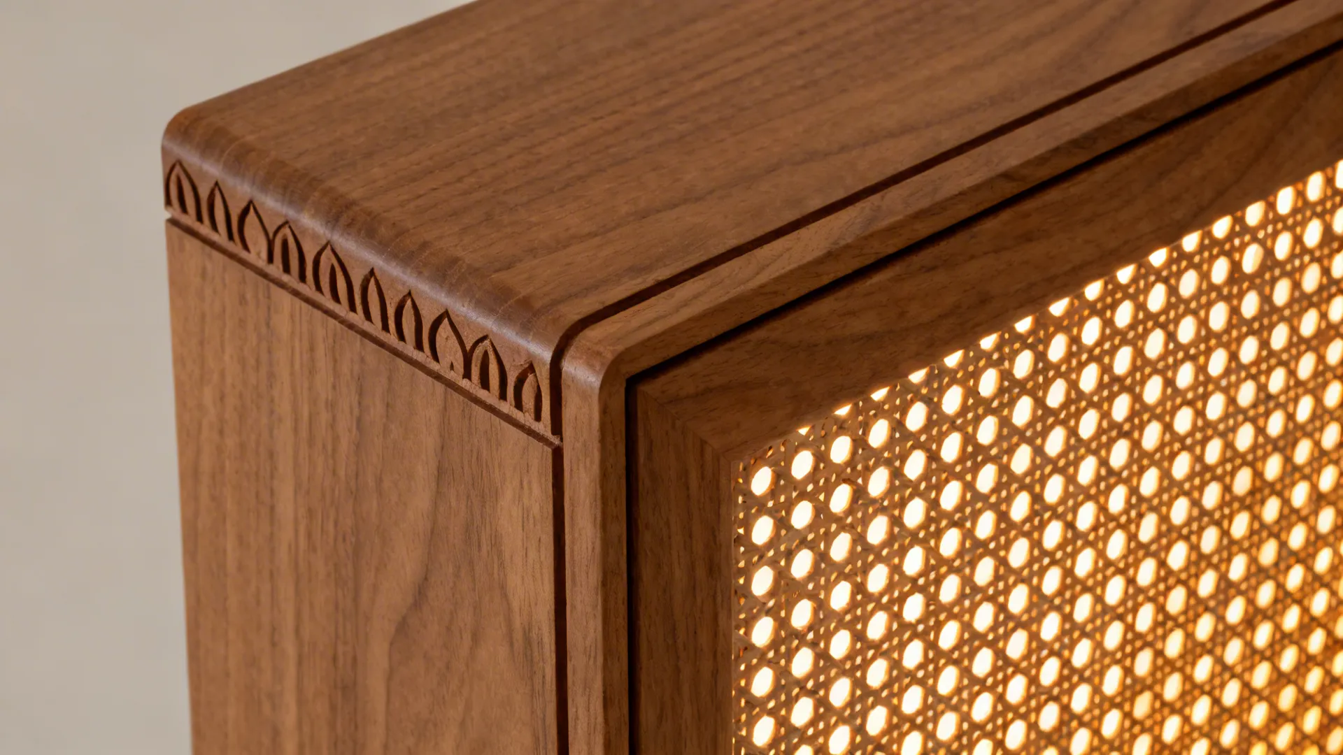 Macro of shallow lotus carving on ash veneer beside evenly backlit jaali.