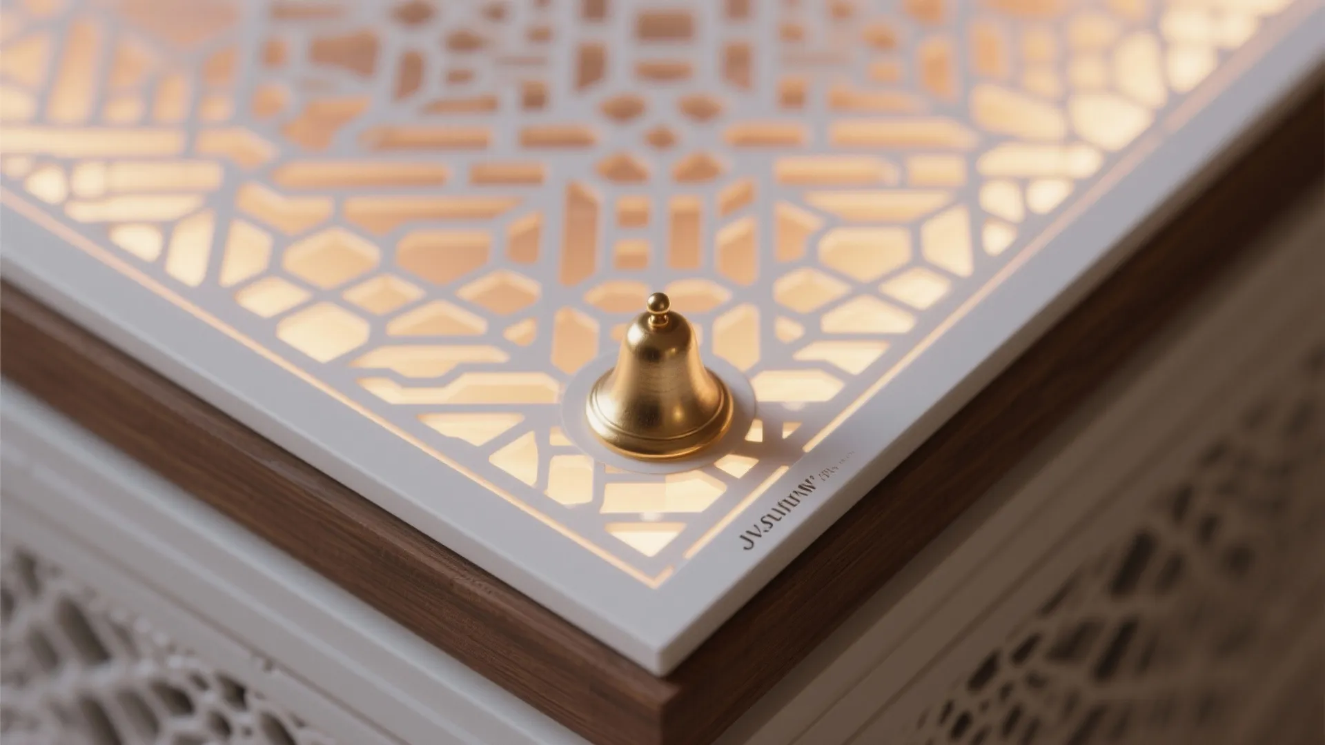 Close up view of a white patterned light panel with a small gold bell on top