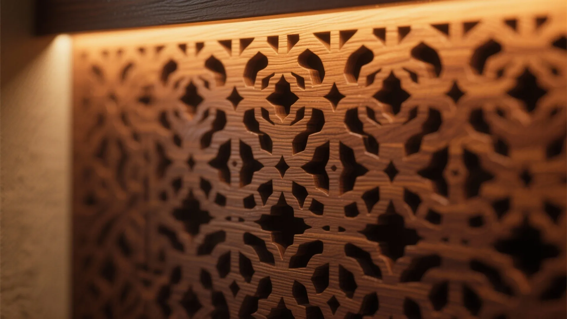 Intricate carved wood wall panel with geometric patterns and warm glowing light from the top