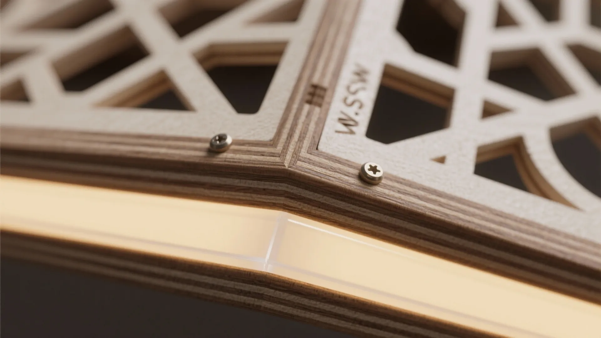 Macro detail of CNC-cut MDF jaali edge with opal acrylic diffuser and warm LED glow.