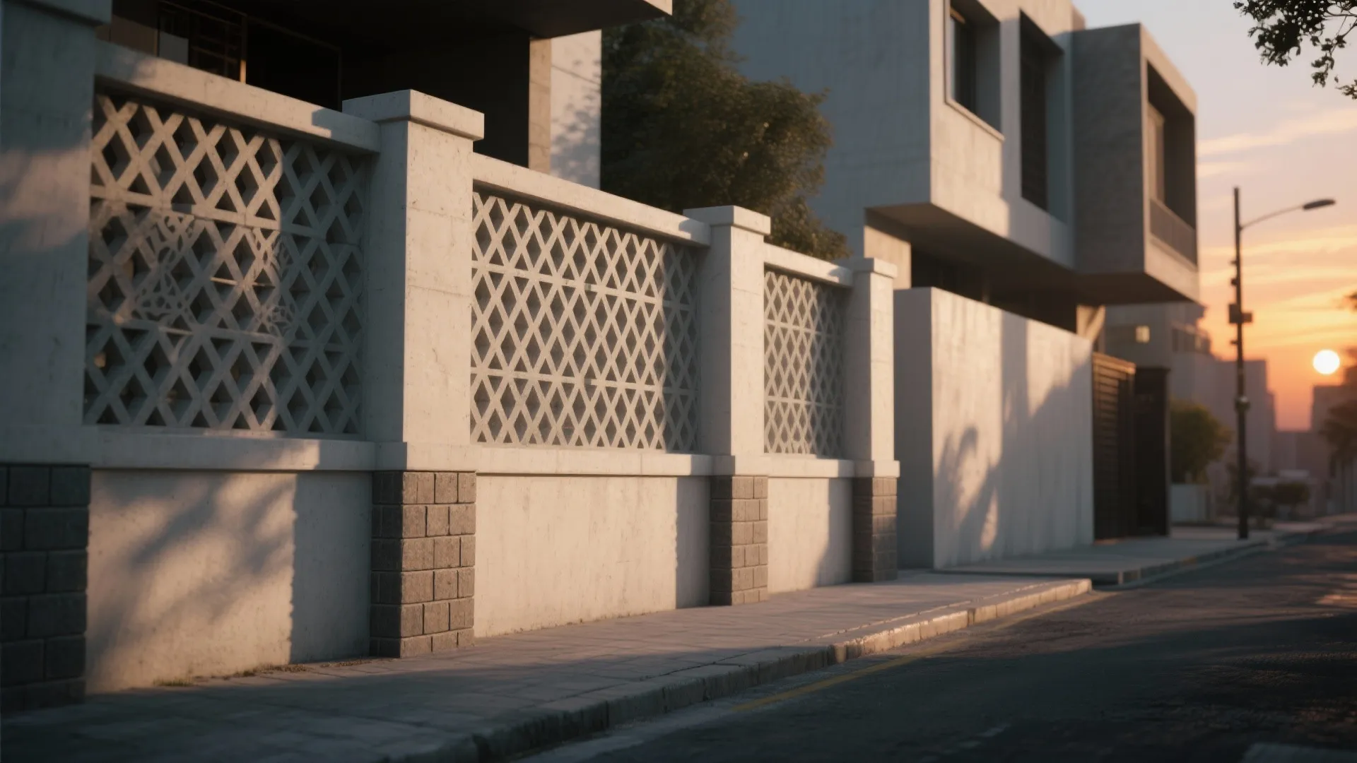 White stone fence with decorative pattern screens along a sidewalk street during a bright sunset