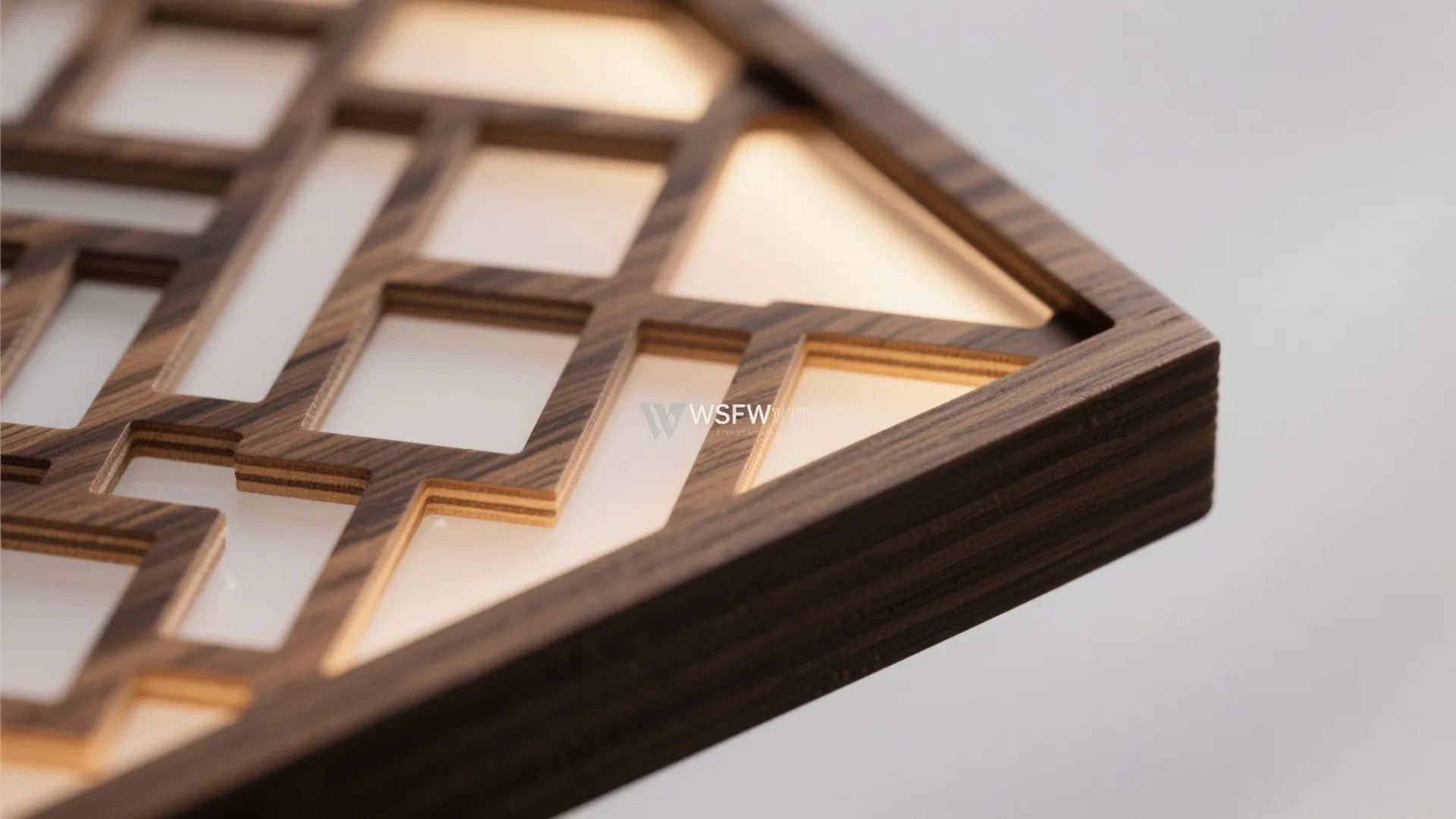 Close up of wooden wall panel with geometric cutouts and warm light glowing from behind