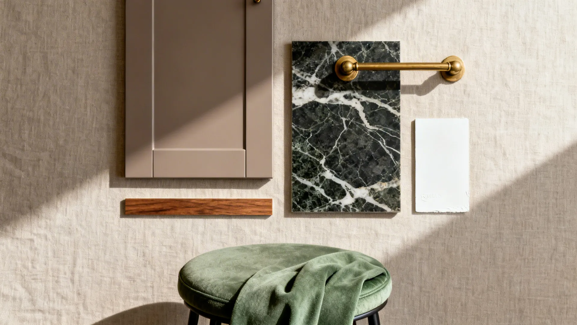 Flat lay of taupe front sample, veined quartz, brass hardware, white paint, wood, and green fabric.