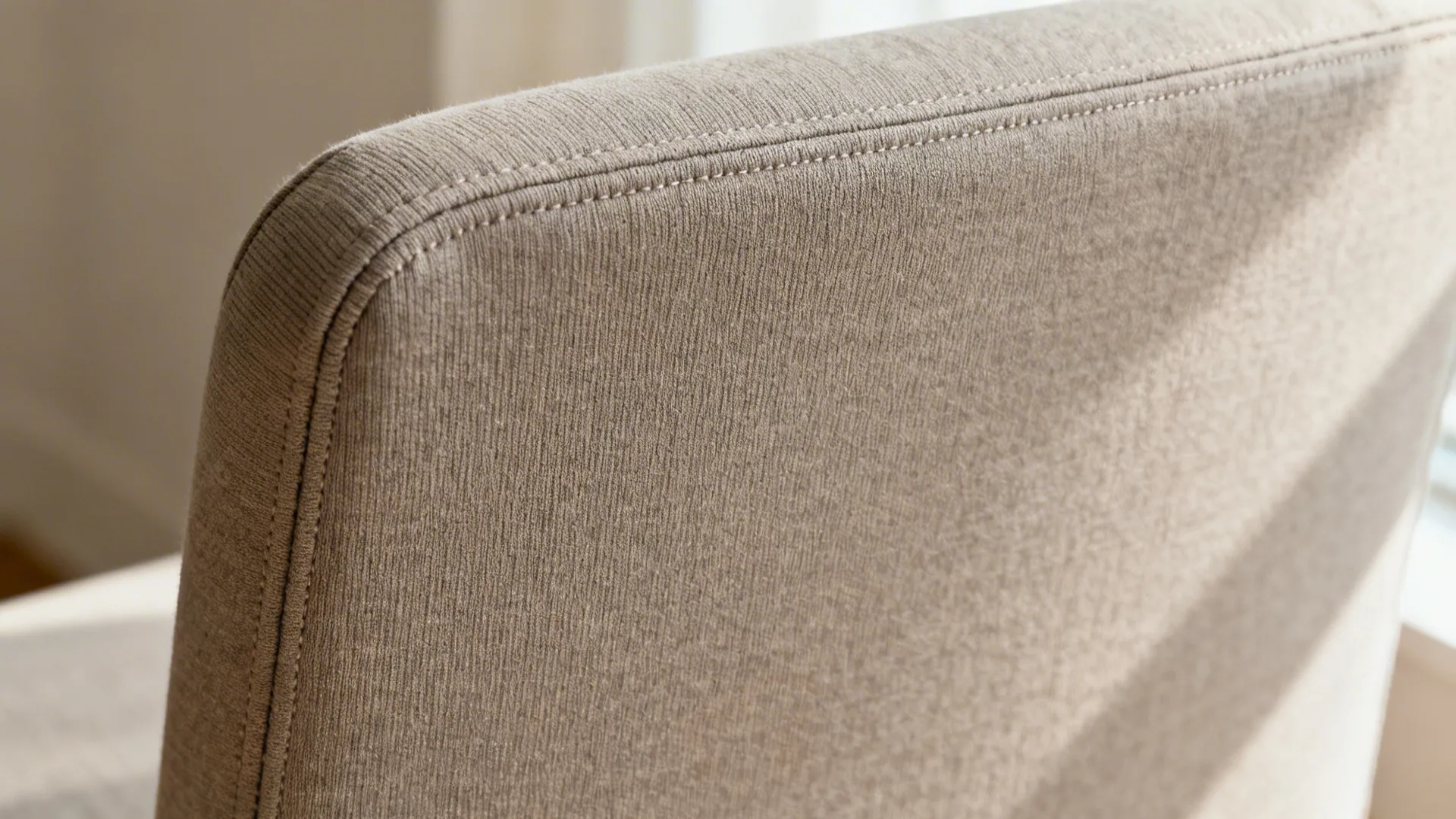 Macro detail of matte performance knit slipcover with tight weave and clean seam.